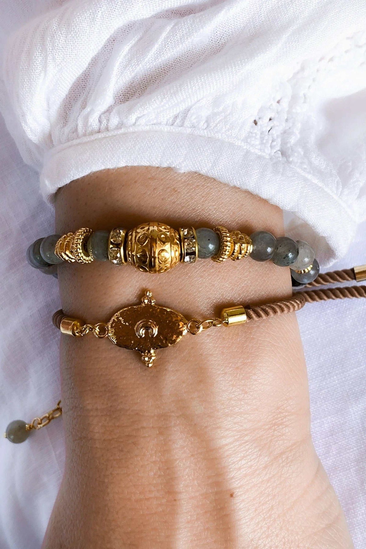Labradorite beaded bracelet with grey polished stone beads, ornate gold-tone accents and a central decorative bead
