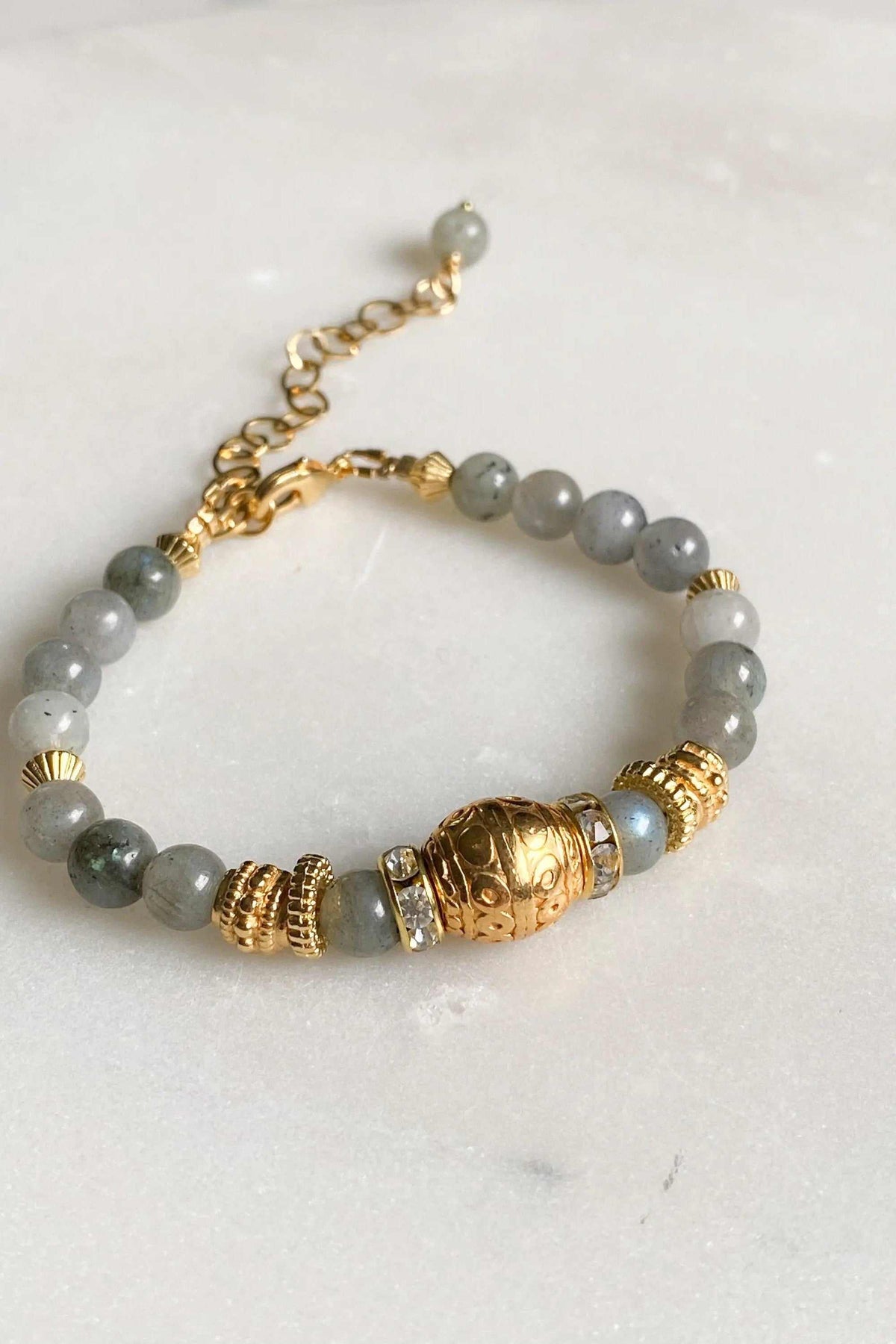 Labradorite beaded bracelet with round grey stone beads, ornate gold-tone spacers and a central engraved barrel bead