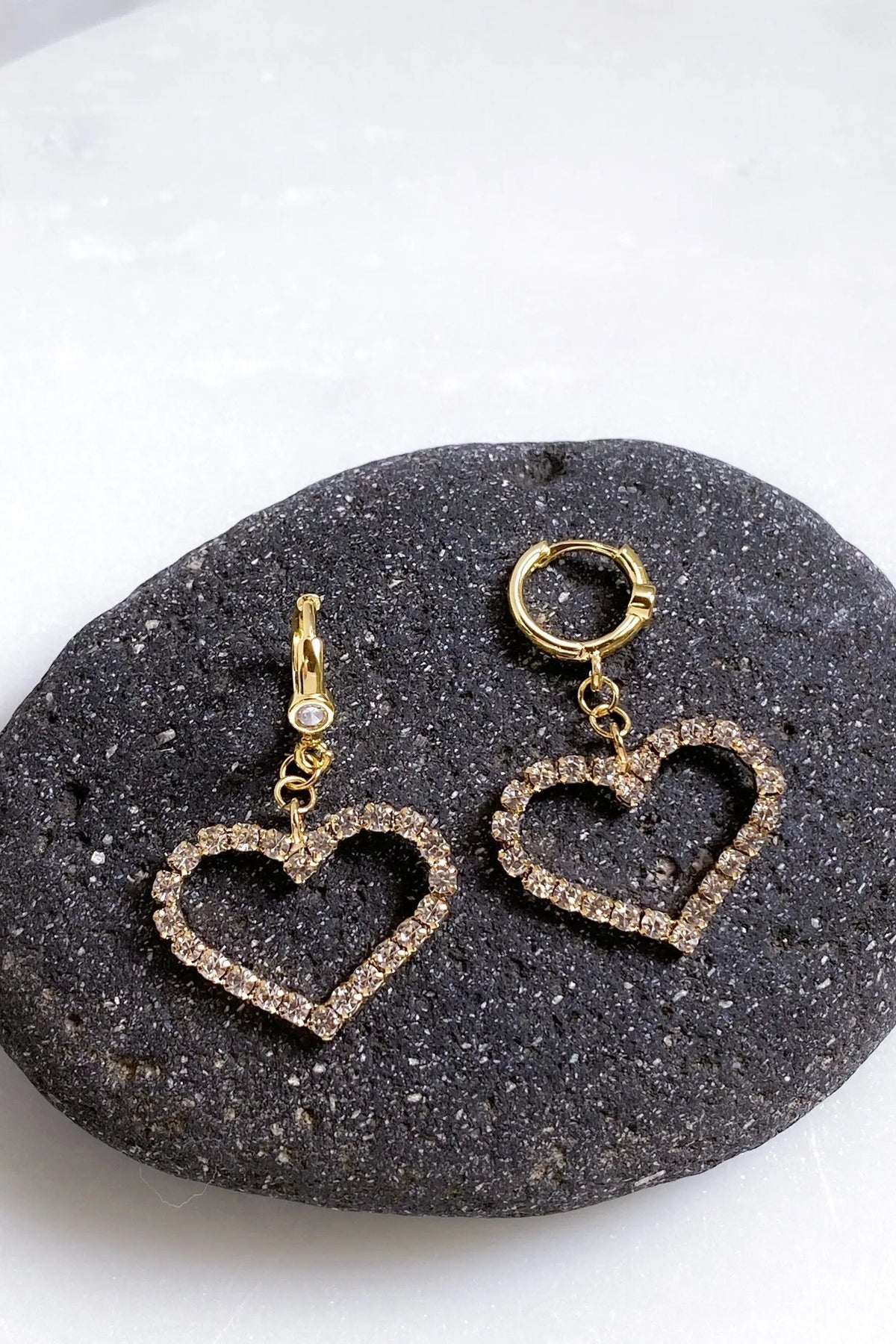 Large Heart Earrings in gold-tone metal, with two open heart charms outlined in sparkling clear crystals and huggie hoops