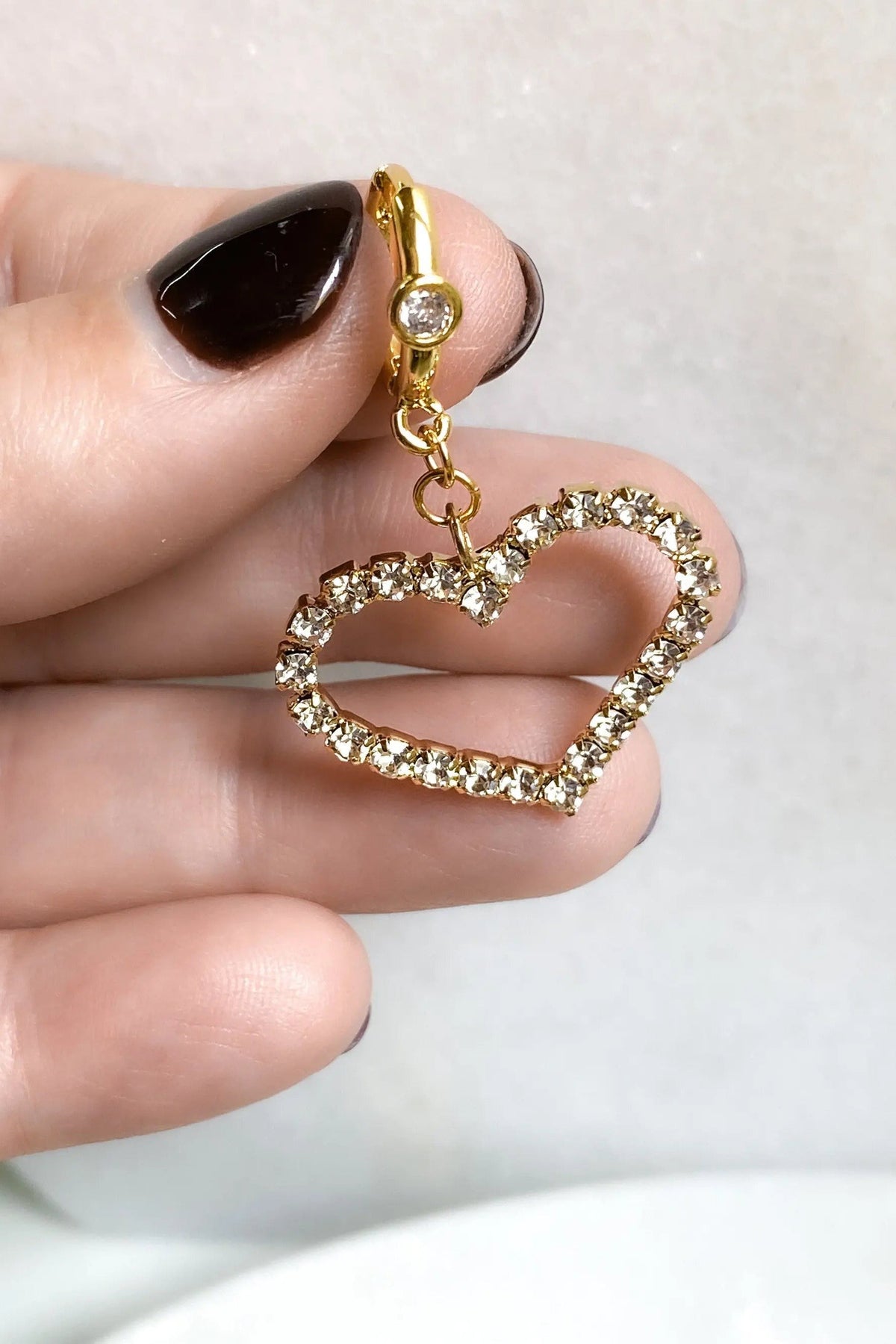 Large Heart Earrings featuring a gold-tone huggie hoop and an open heart charm outlined with clear crystals