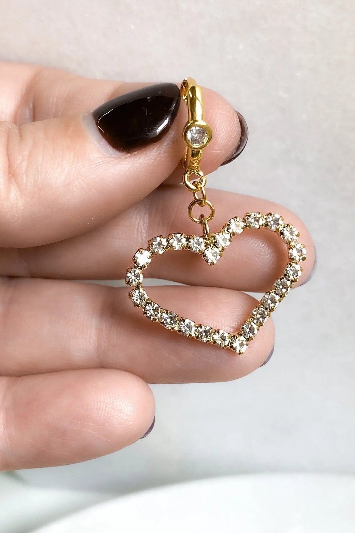 Large Heart Earrings with gold-tone huggie hoops and open heart charms outlined in clear crystals