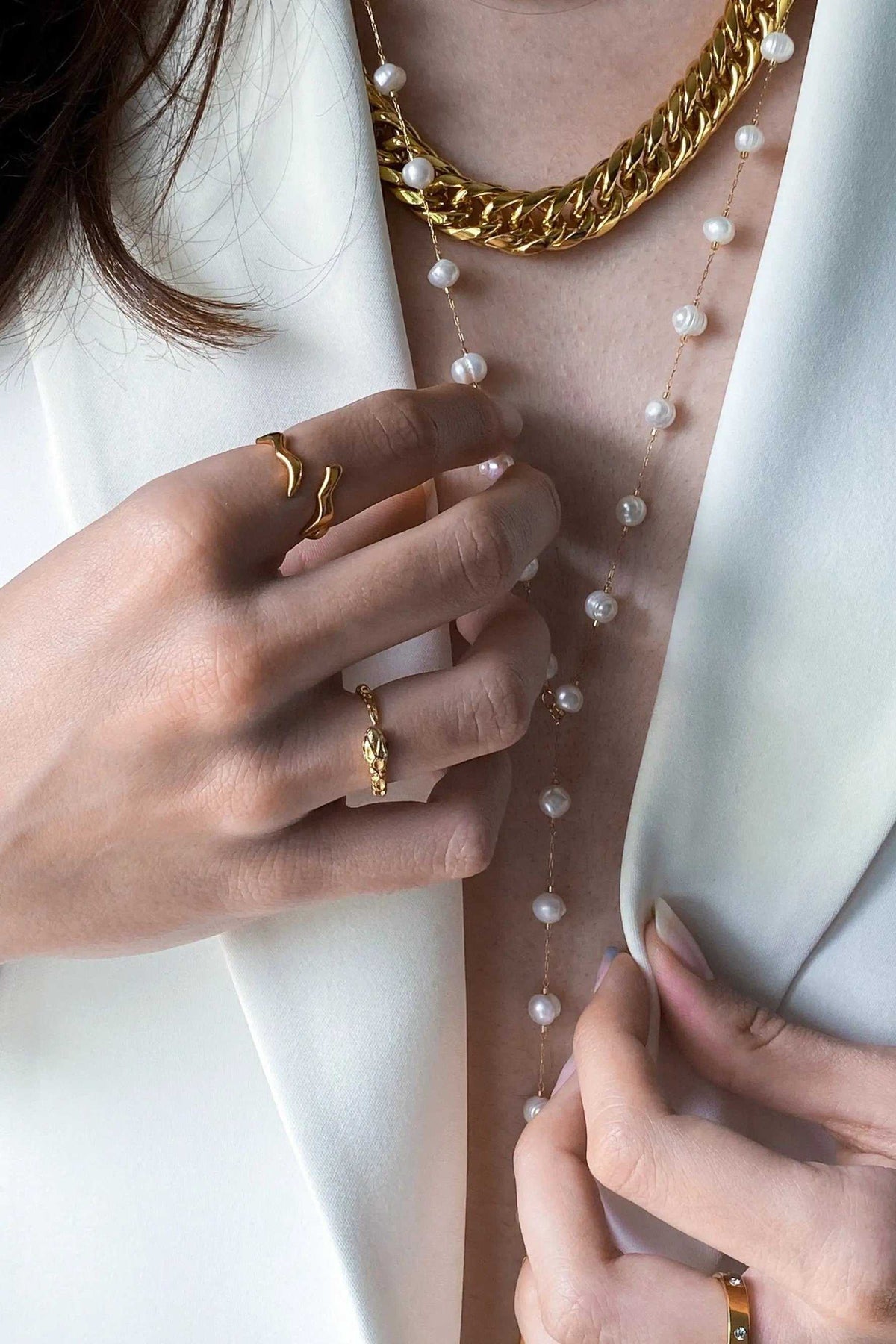 Lariat pearl necklace with a delicate gold chain and evenly spaced freshwater pearls, worn as a long Y necklace