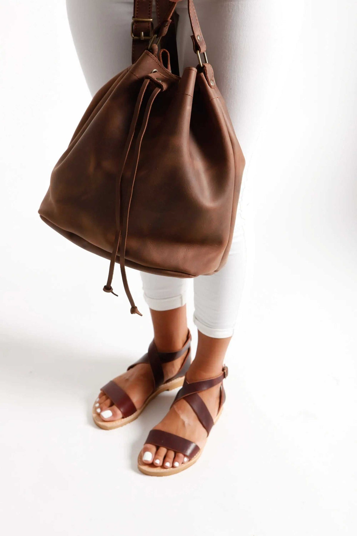 leather women's handbag in rich brown leather with a soft bucket shape, drawstring closure and adjustable shoulder strap