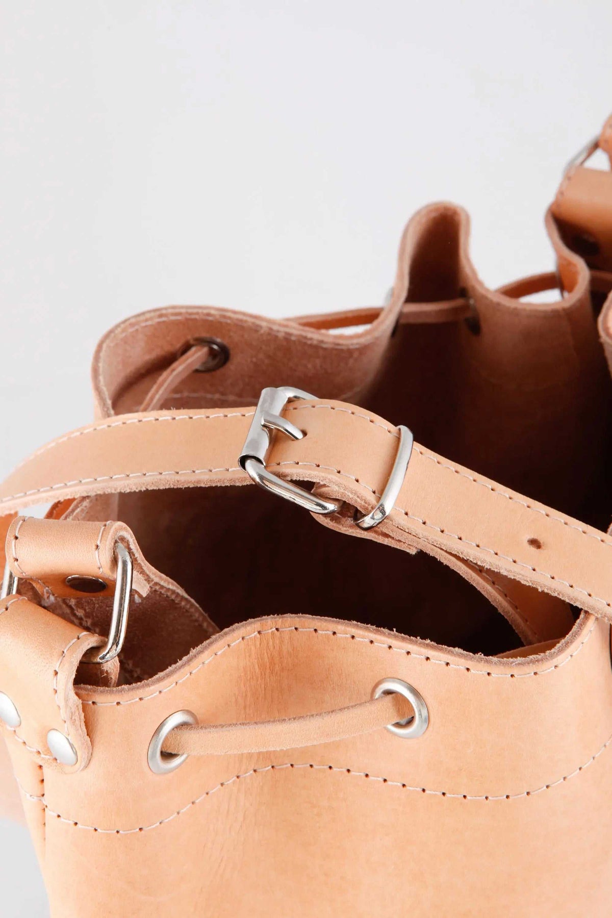 Leather women's handbag in natural tan full-grain leather with bucket shape, drawstring closure and adjustable strap