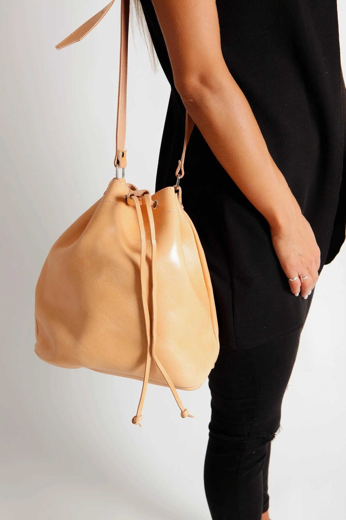 Leather women's handbag in natural tan leather, soft bucket shape with long drawstring closure and adjustable strap
