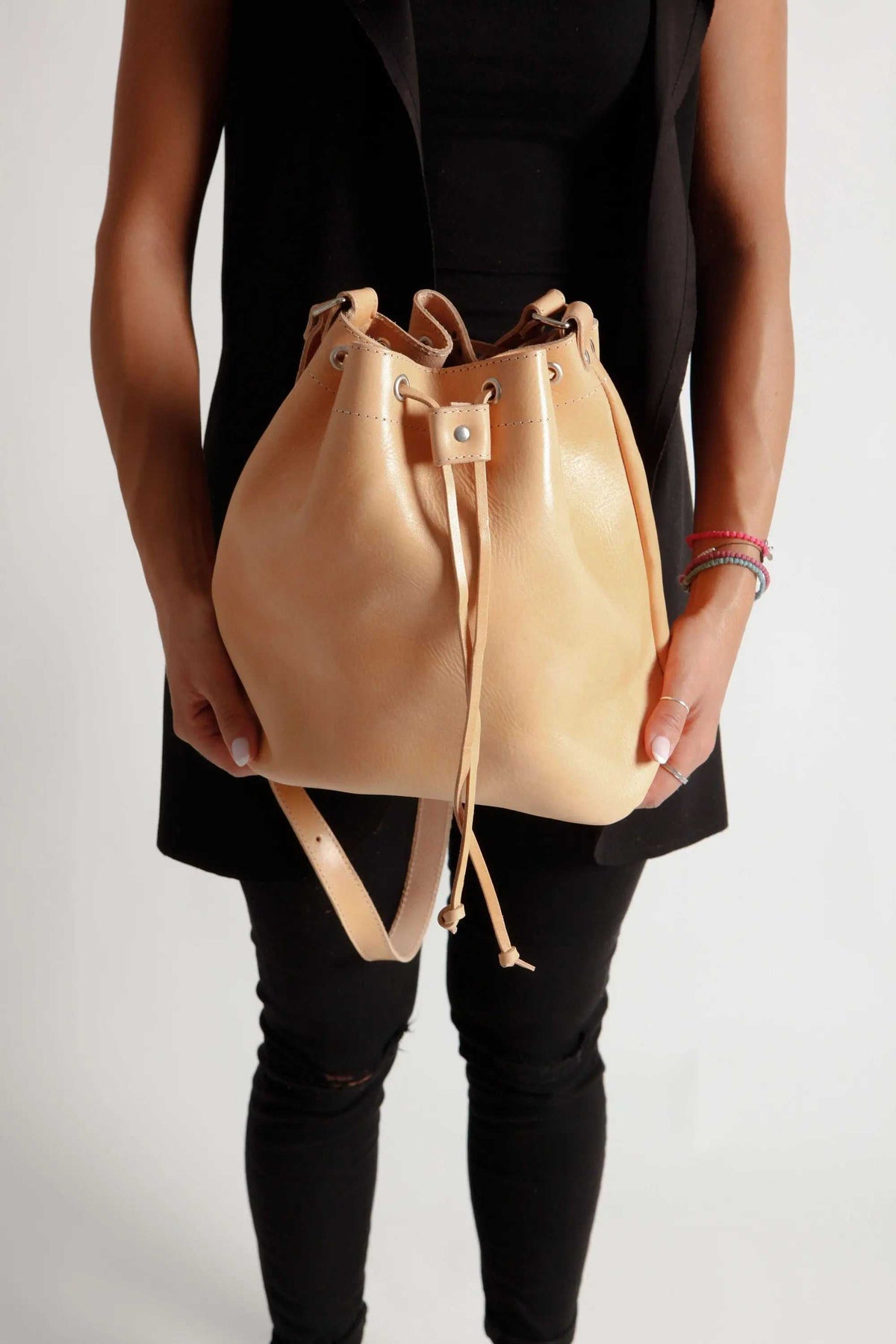 leather women's handbag in tan full-grain leather with a bucket shape, drawstring closure and adjustable shoulder strap