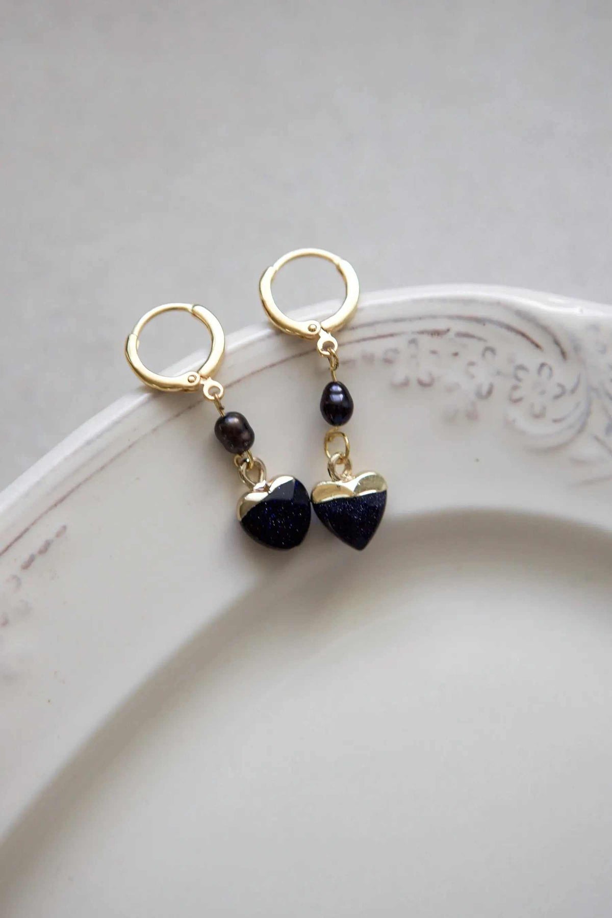 Little Heart dangle earrings with dark blue textured heart charms, black beads, and gold-tone hoops