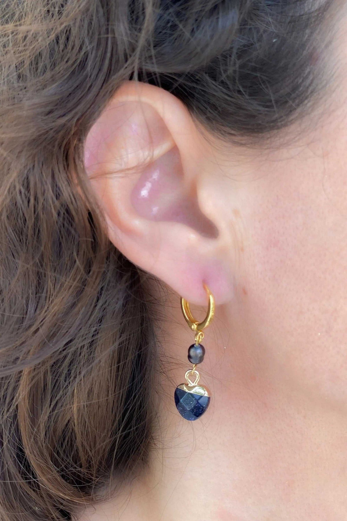Little Heart dangle earrings in gold-toned metal with dark blue faceted heart and small dark pearl
