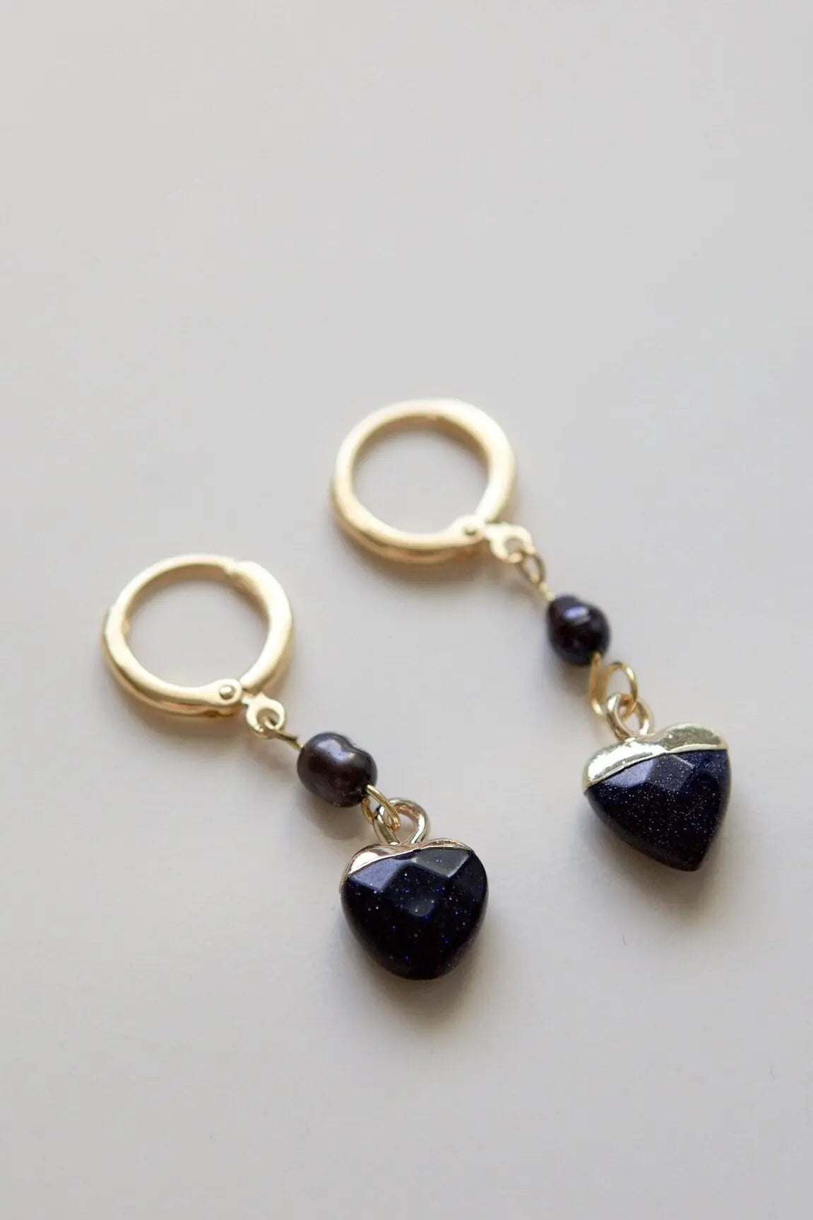 Little Heart dangle earrings with dark blue speckled heart charms and black round beads in gold-tone metal
