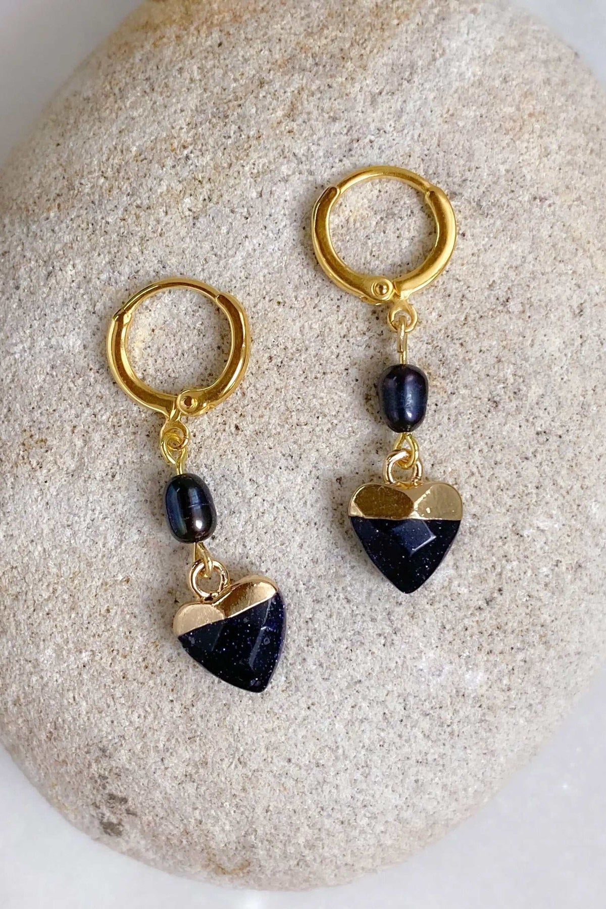 Little Heart dangle earrings with gold-tone hoops, dark blue glittering heart charms and black oval beads.