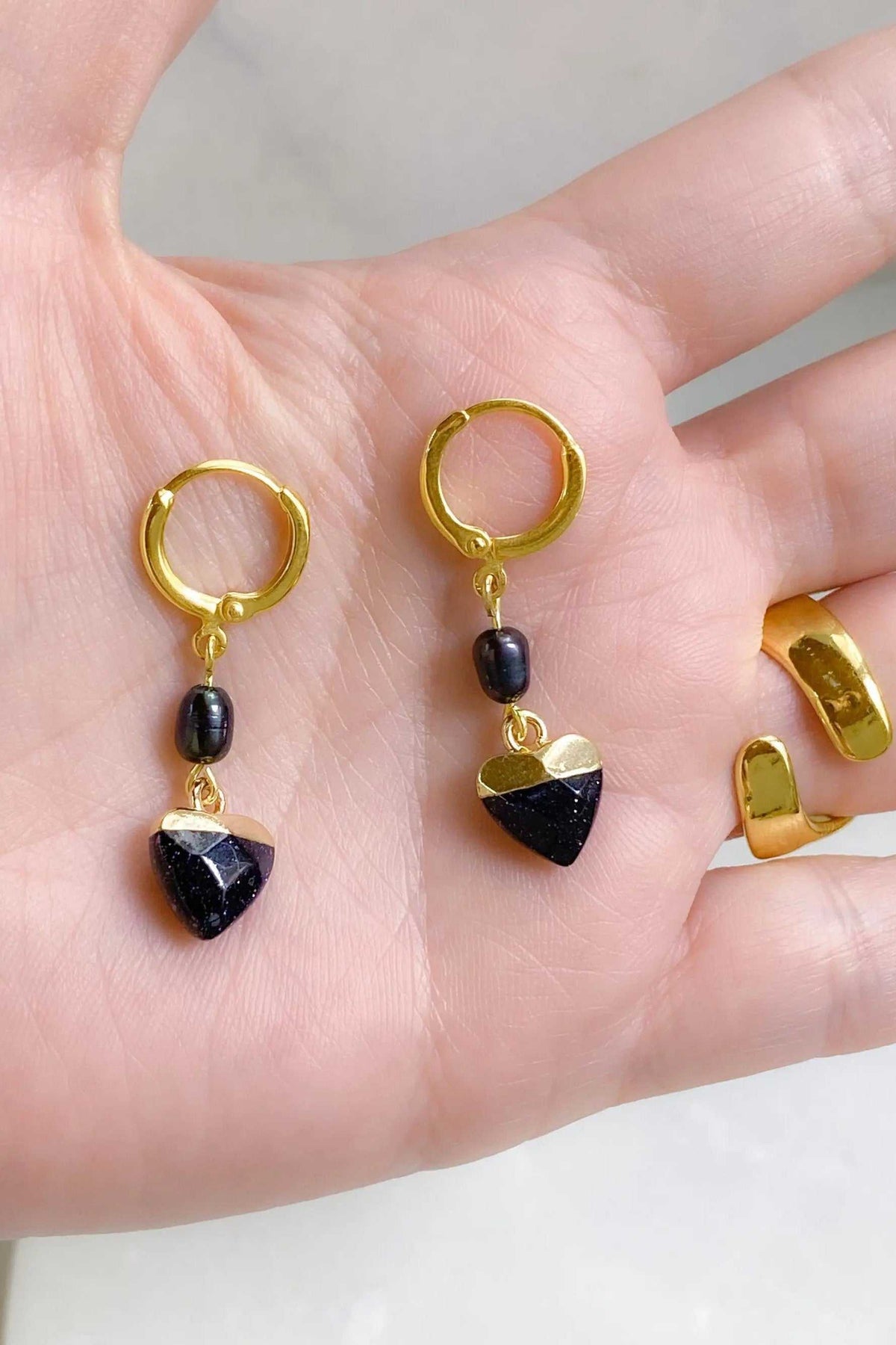 Little Heart dangle earrings with gold-tone hoops, black beads and faceted dark blue heart-shaped stones