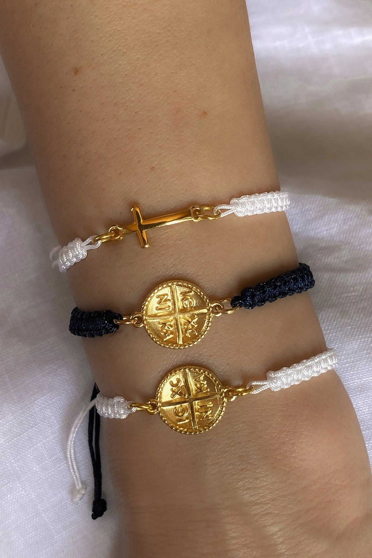 Macrame braided Bracelet with white and dark blue cords, featuring gold cross and Byzantine coin motifs