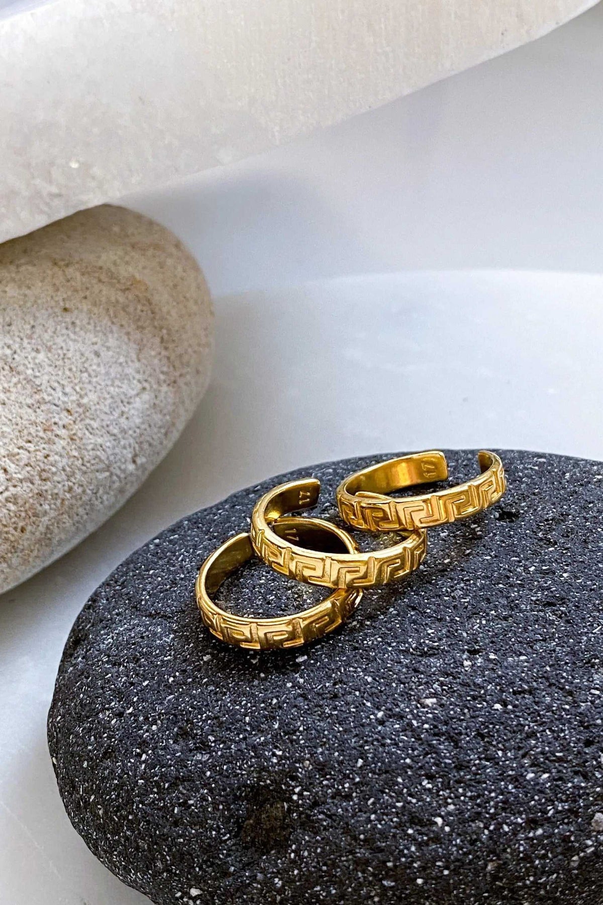 MEANDER Gold band Ring in gold-tone metal with a raised Greek meander pattern and open adjustable band