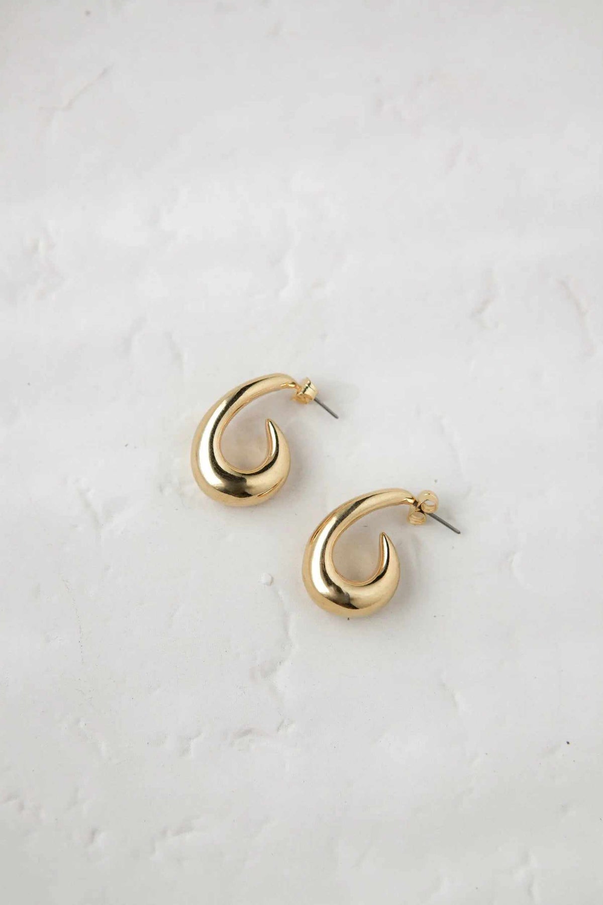 Medium chunky hook Hoops in polished gold-tone metal, with thick open curved shapes and visible titanium pins