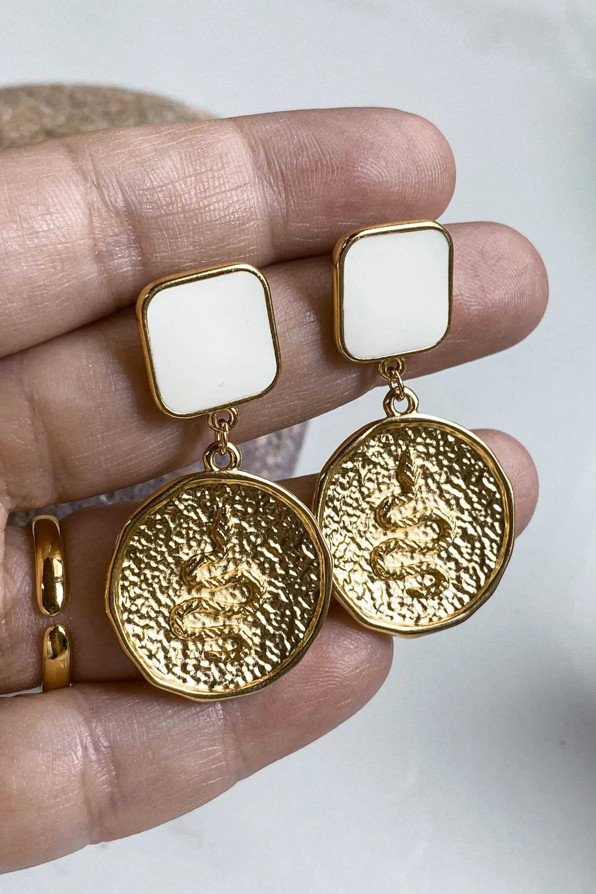 MEDUSA Gold Coin Earrings in gold with textured round Medusa coin pendants and white rectangular tops