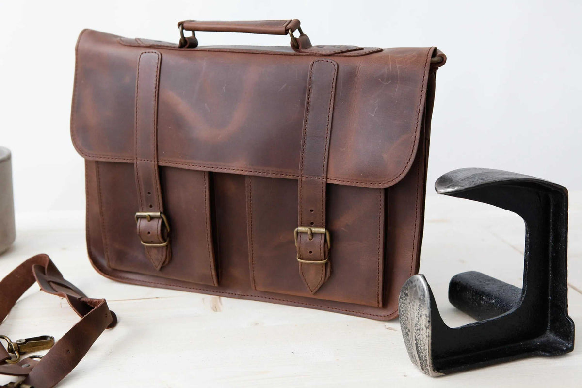 MEN'S BRIEFCASE with pocket in distressed brown leather, featuring a top handle, front flap and two buckle straps
