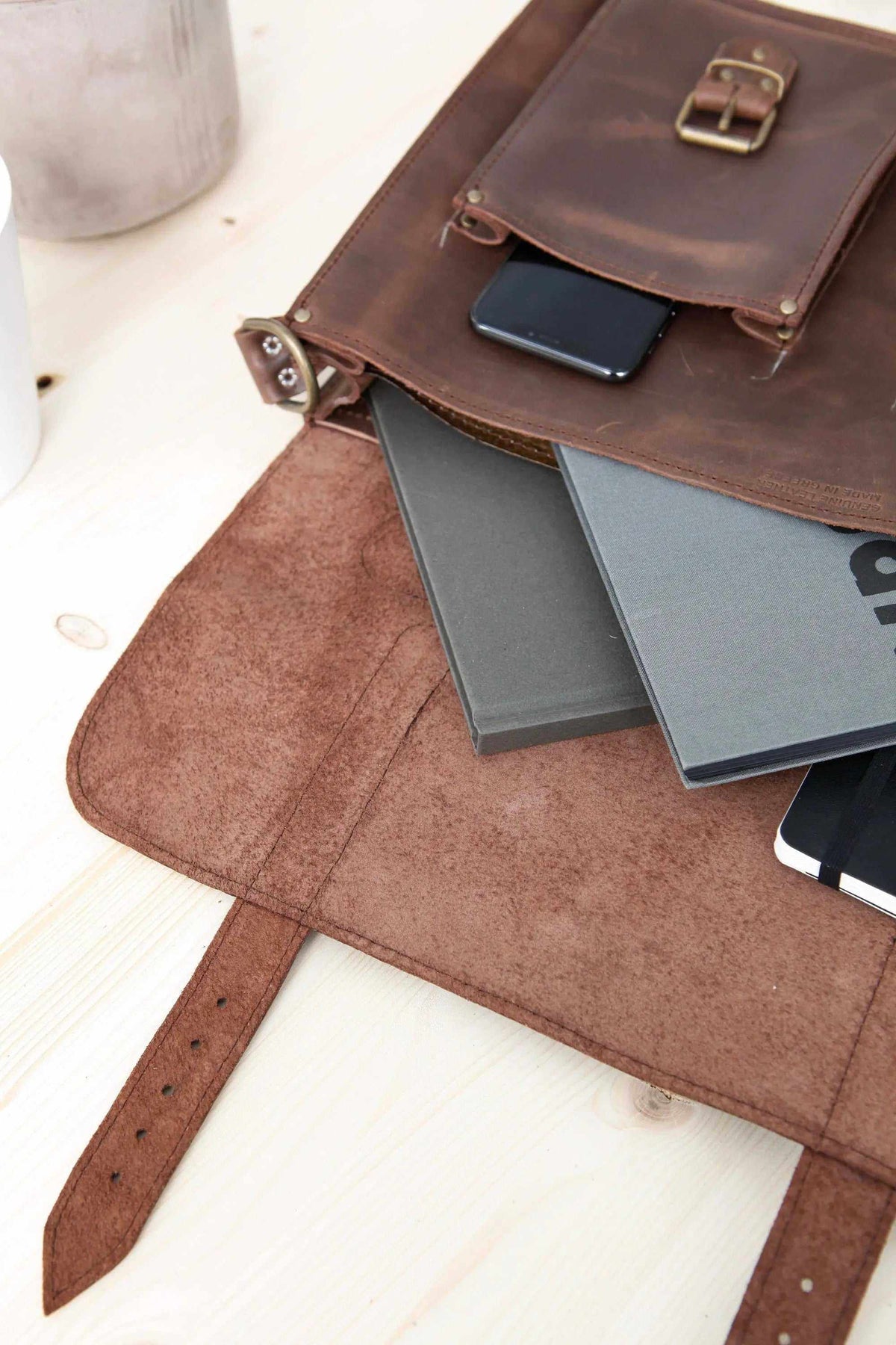 MEN'S BRIEFCASE with pocket in brown leather, featuring a buckle flap, adjustable strap, and spacious interior