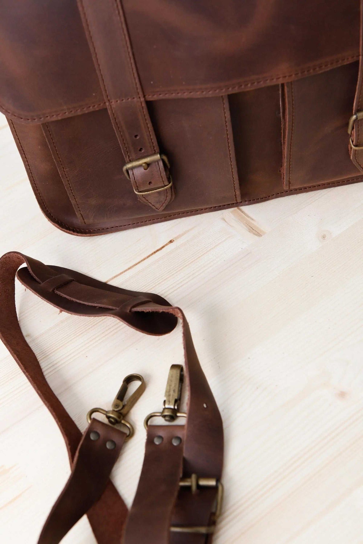 MEN'S BRIEFCASE with pocket in dark brown leather, featuring front compartments, buckle closure and a detachable shoulder strap