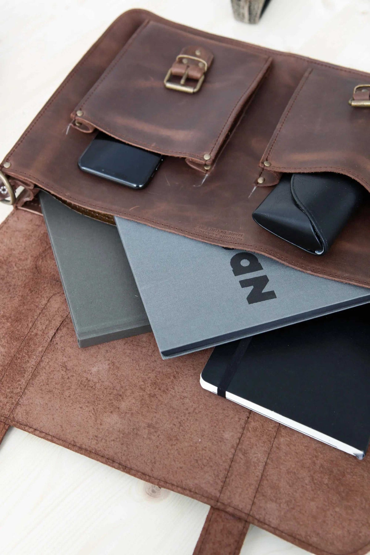 MEN'S BRIEFCASE with pocket in dark brown leather, featuring two front flap pockets with metal buckles and stitched edges