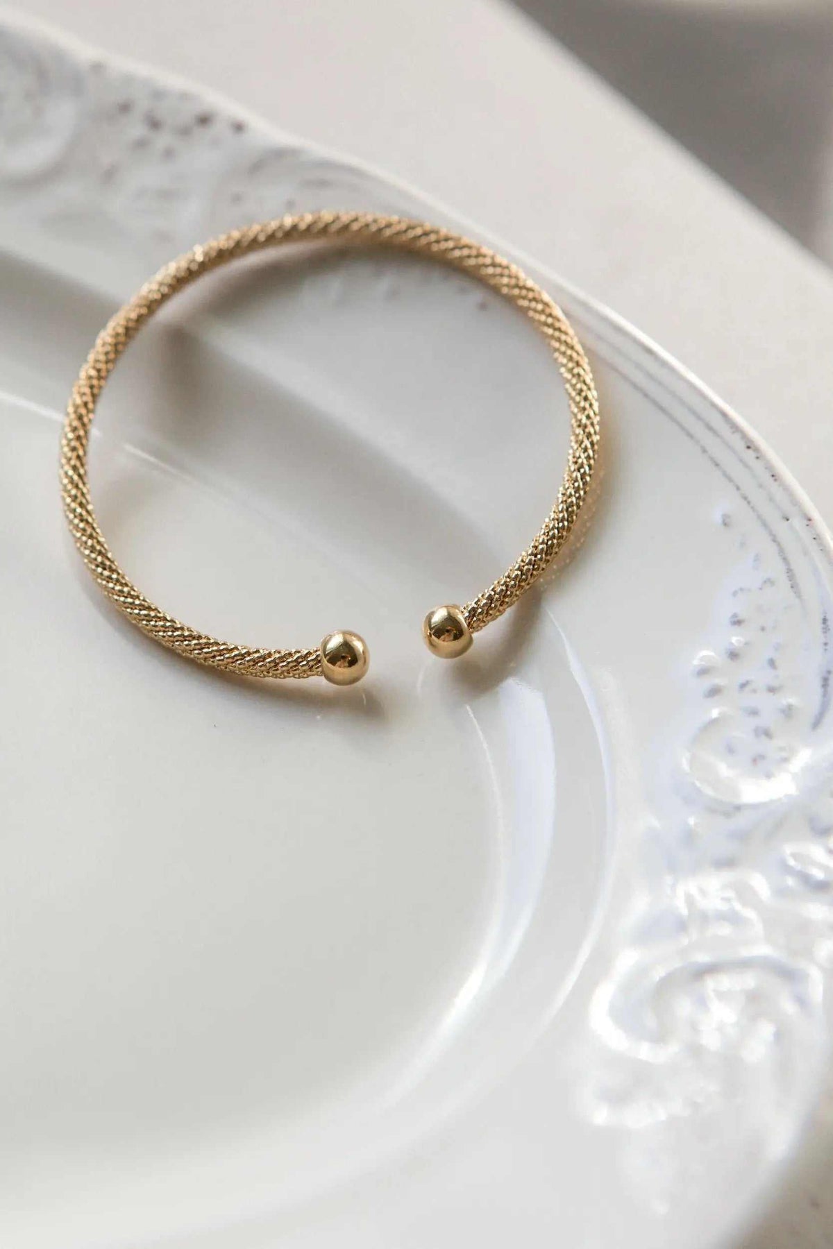 Minimal Twisted rope Bracelet in gold-tone metal with a finely braided texture and two polished ball ends