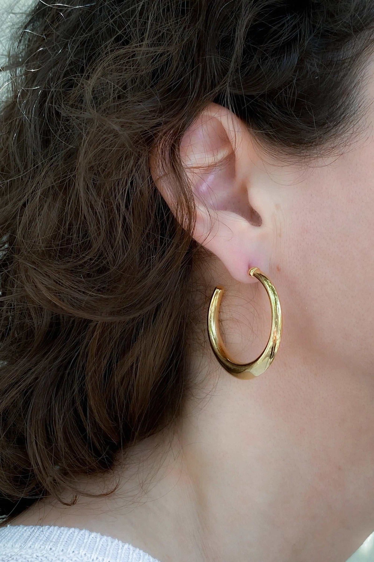 Minimalist 24k gold plated hoop earrings, smooth shiny gold-tone metal with a large rounded hoop design