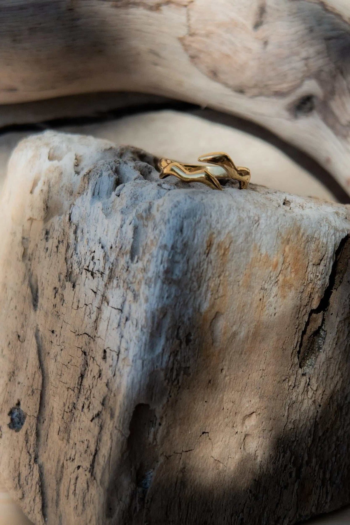Minimalist gold filled ring in a warm gold tone, featuring an open geometric band with a sculptural wave shape