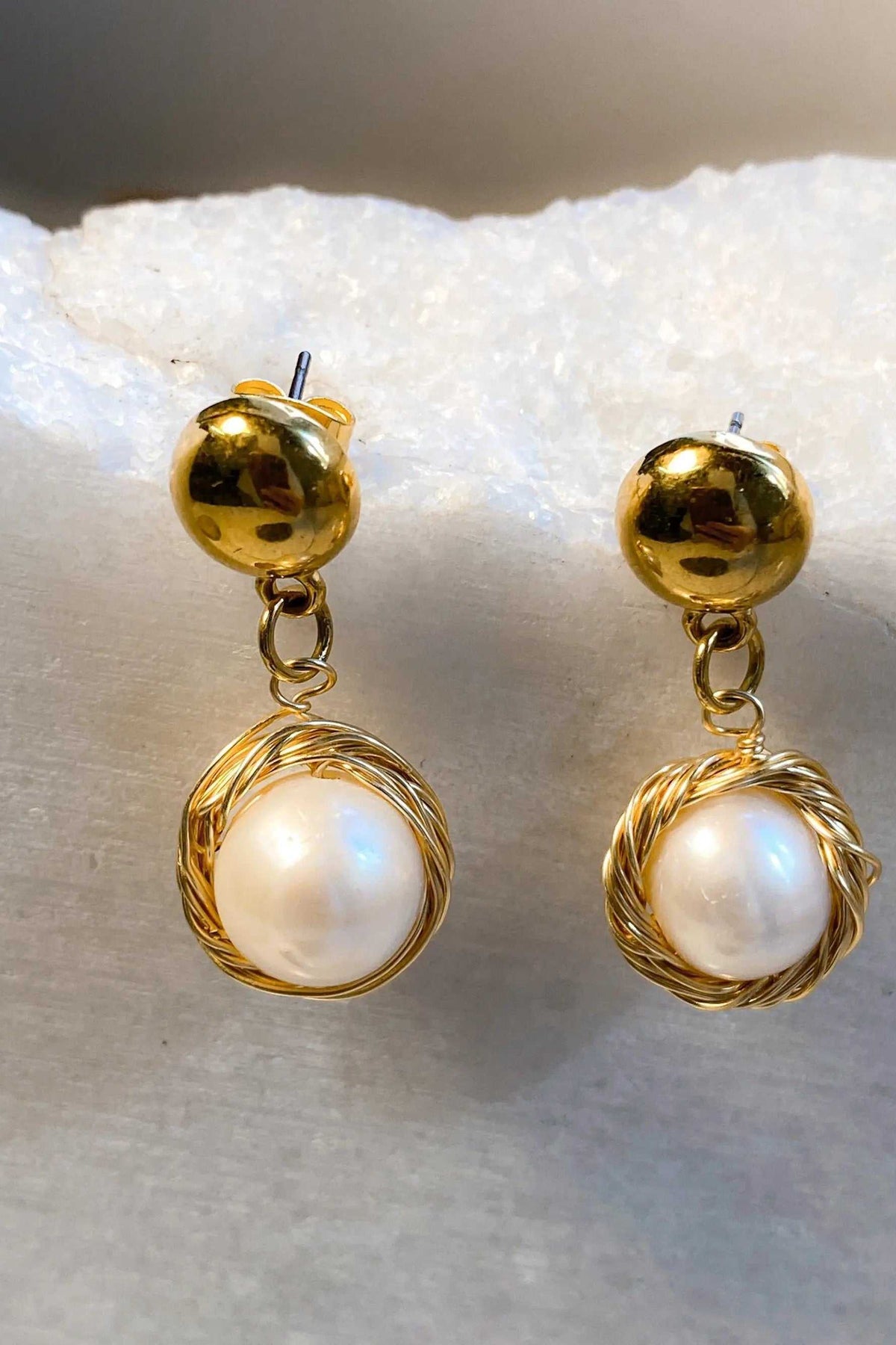 Mother of pearl Earrings with round white pearls in textured gold-tone wire frames and polished stud tops