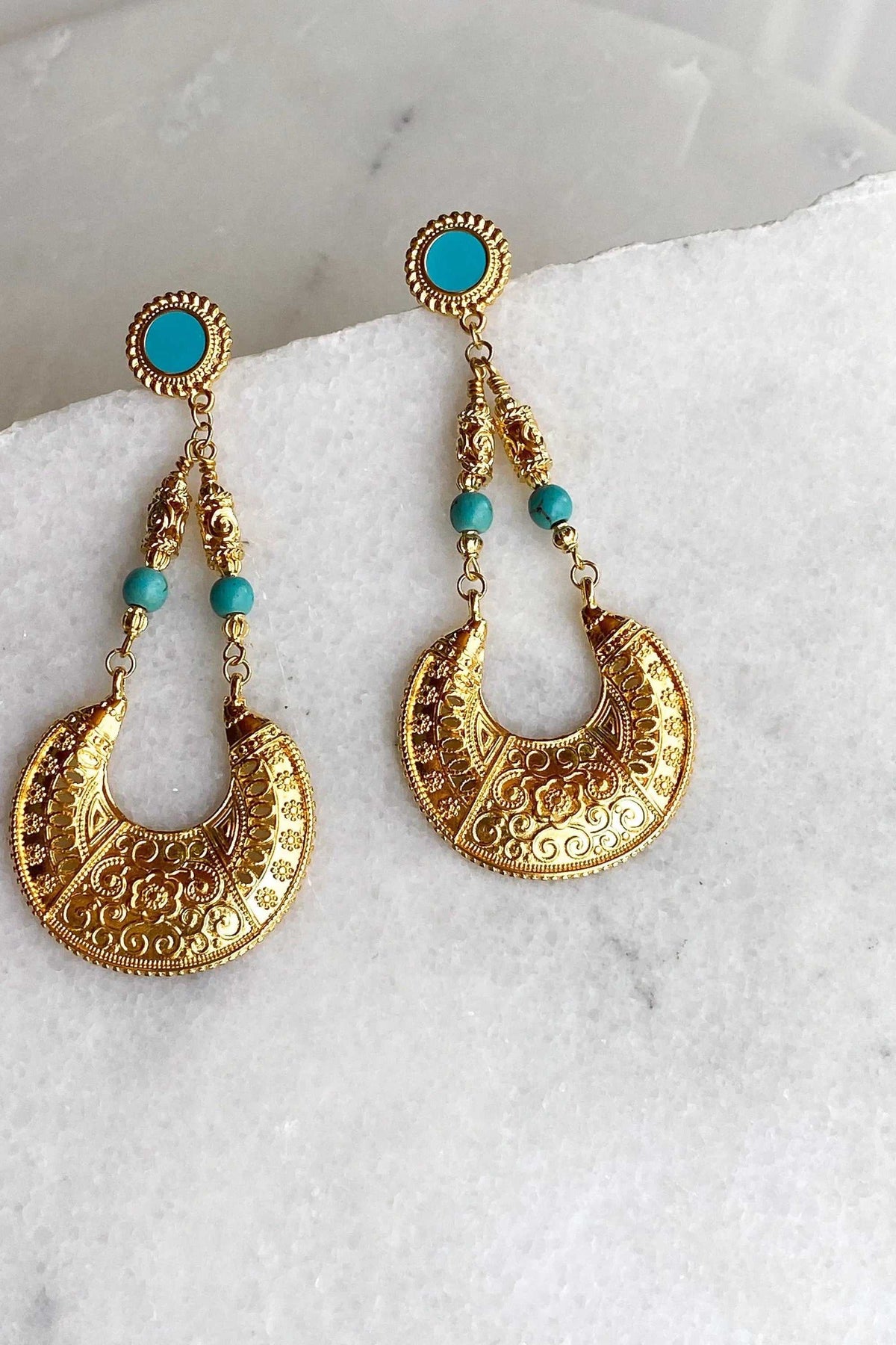 MYRTÓ EARRINGS feature ornate gold-tone brass crescent drops with turquoise stud tops and bead accents