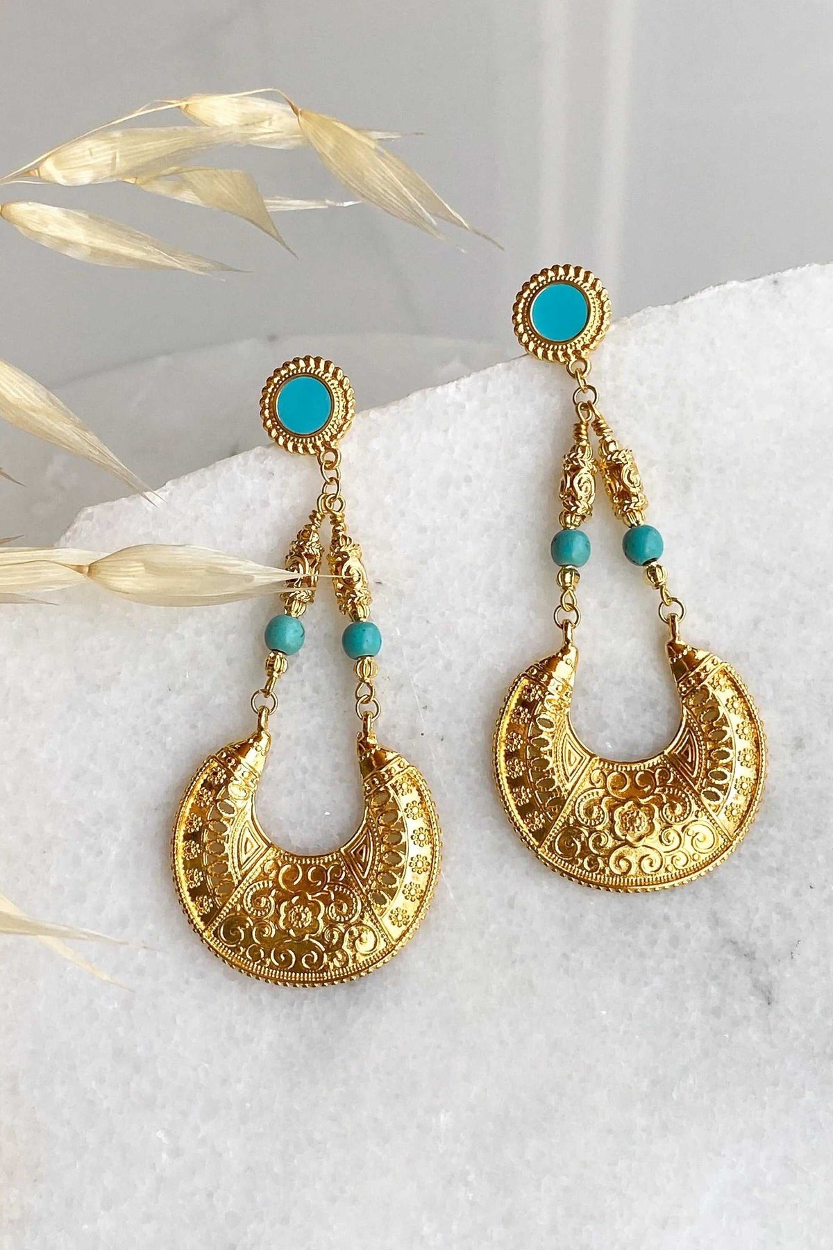 MYRTÓ EARRINGS are oversized gold-tone filigree drops with turquoise studs and bead accents in an ornate crescent design