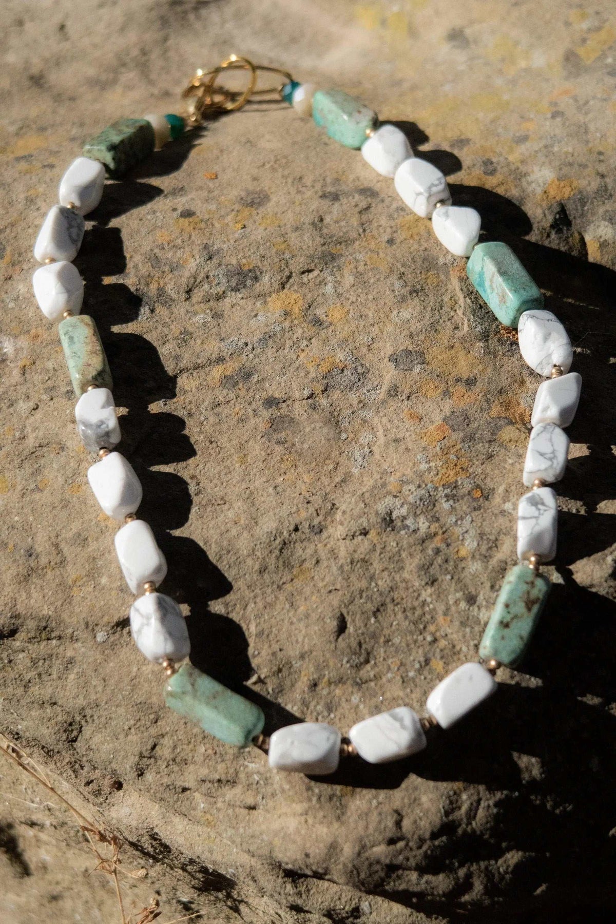 Necklace Crystal Gemstone with white and pale green irregular stone beads, gold-tone spacers and a heart charm