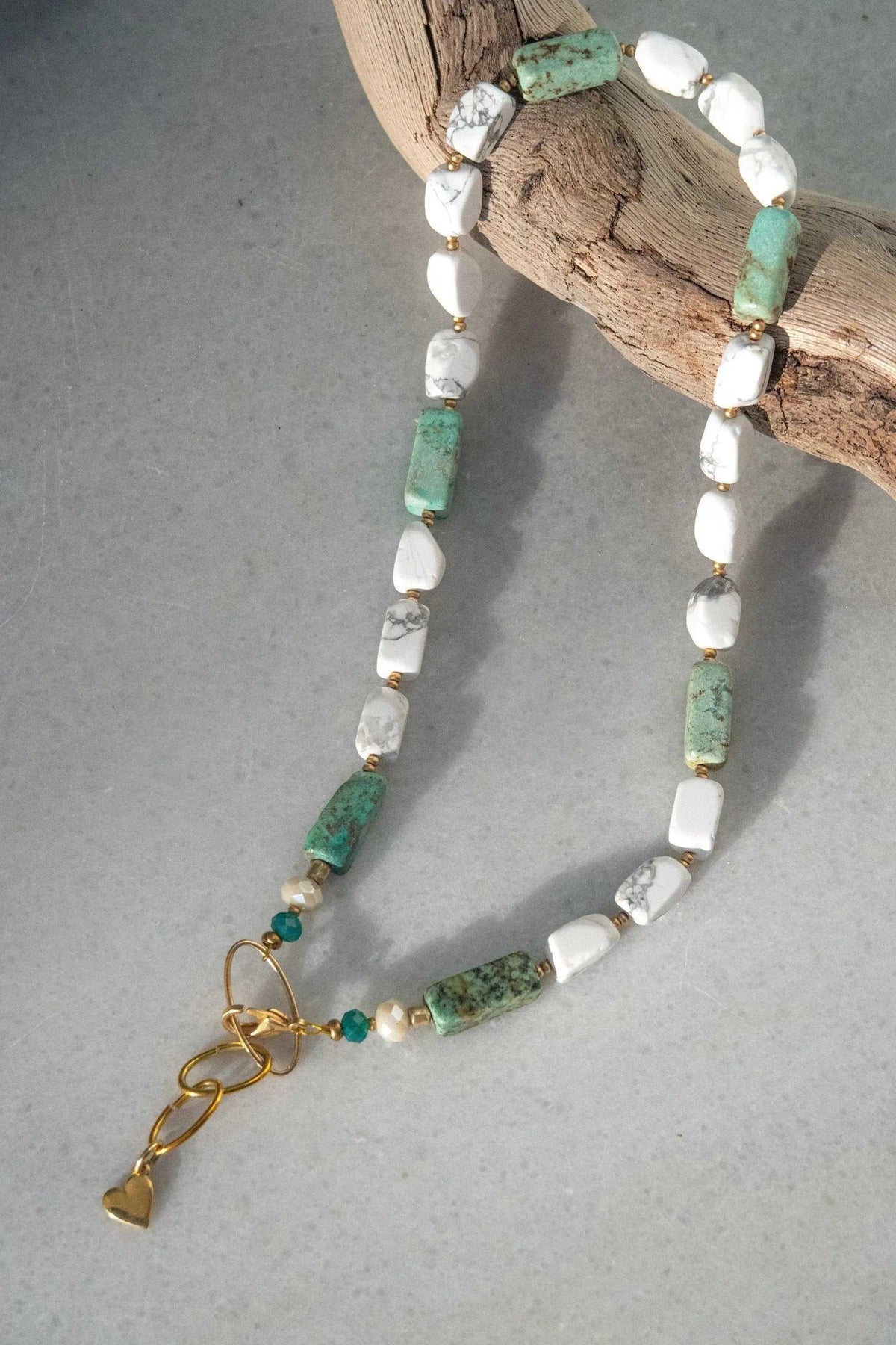 Necklace Crystal Gemstone featuring irregular white and green stones, gold-tone accents, and a dangling heart charm