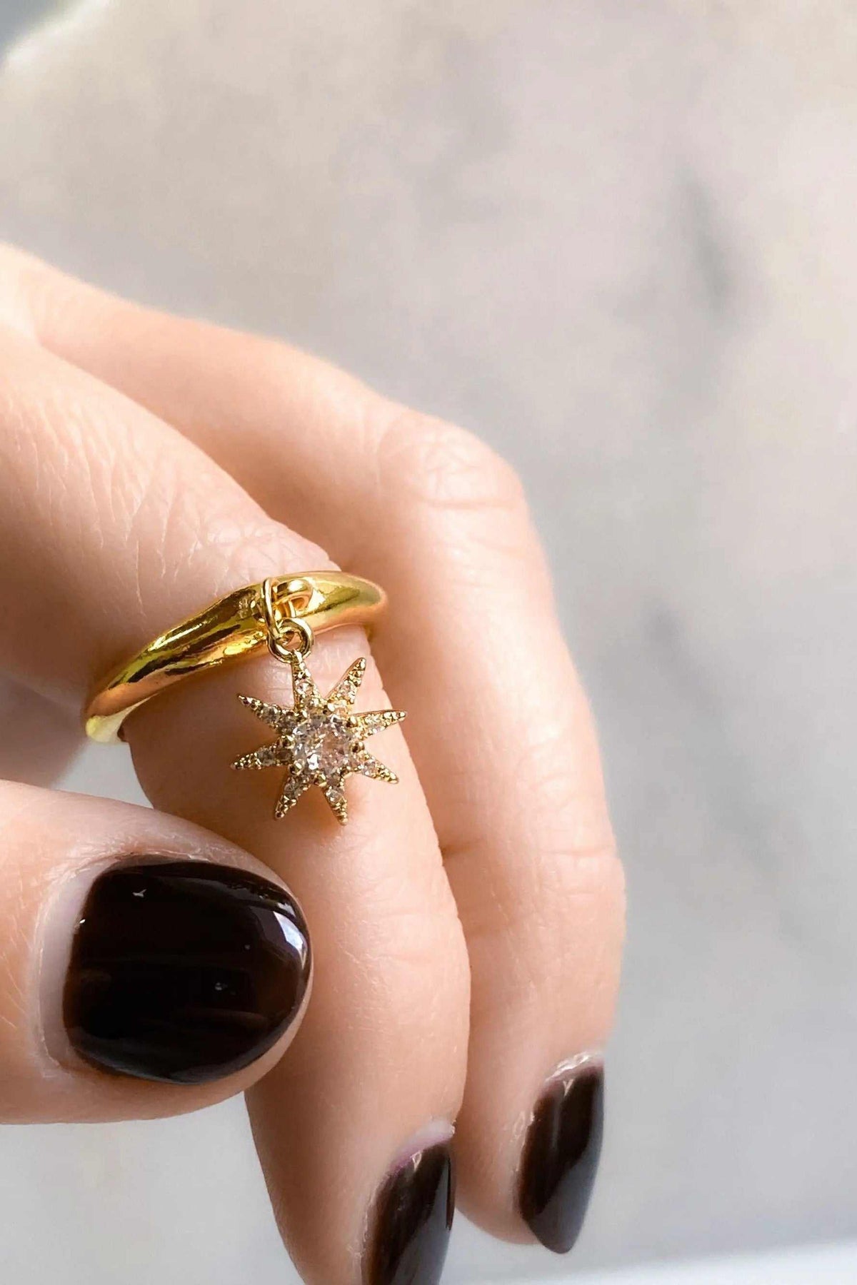 NORMA Ring, gold-tone adjustable band with a dangling star-shaped pendant set with sparkling clear stones