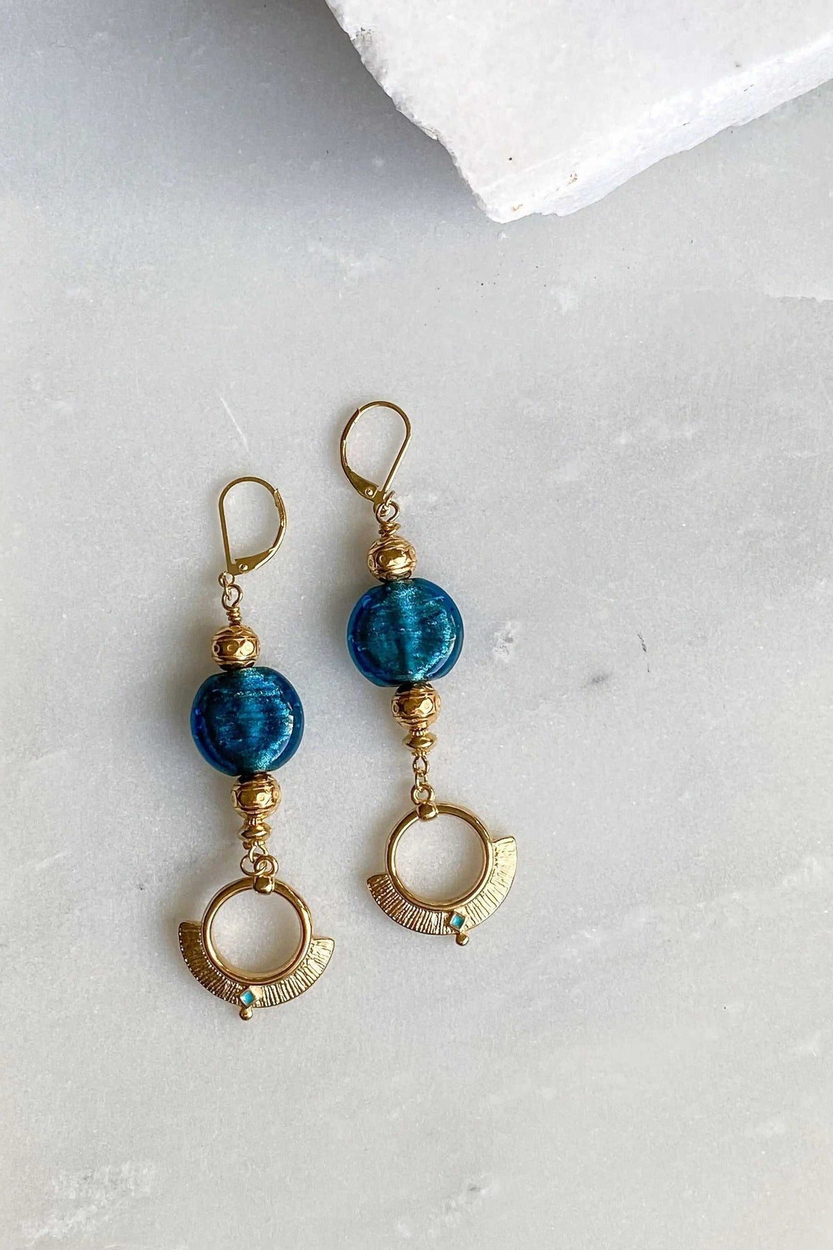 ODYSSOS EARRINGS with blue glass beads, gold-toned metal details and circular etched drop charms
