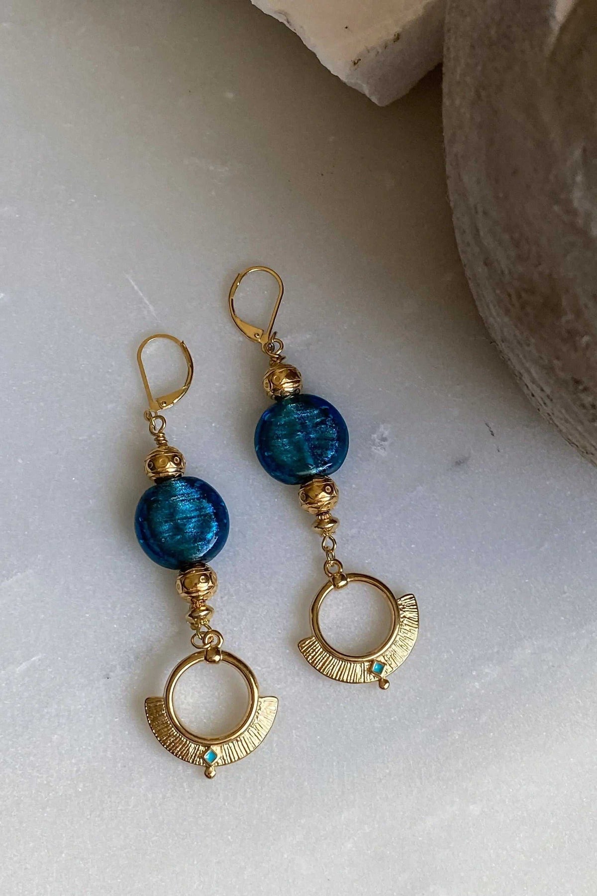 ODYSSOS EARRINGS, gold-tone brass with blue glass beads and ornate circular drop details