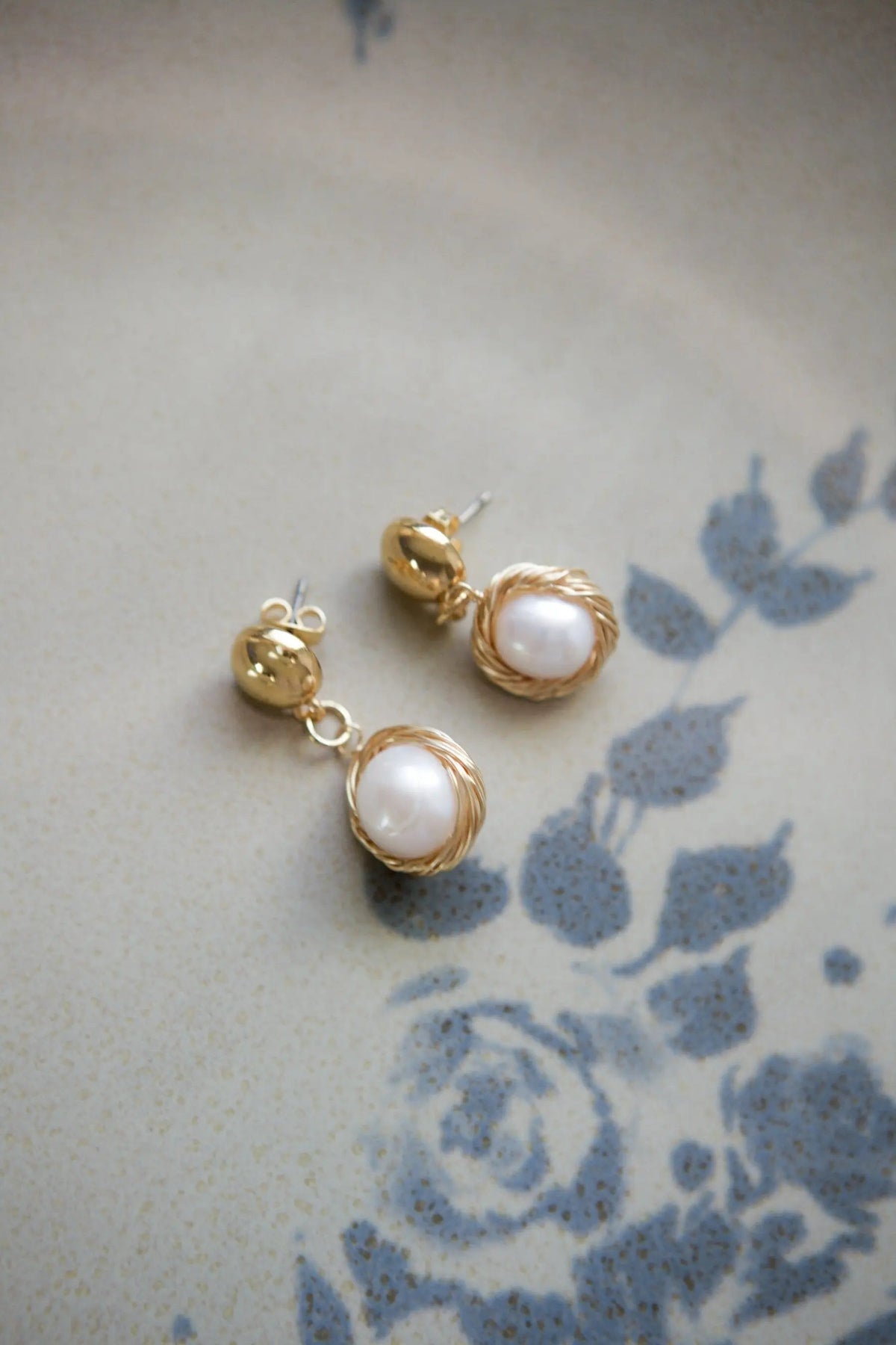 Pearl wreath Earrings in gold-toned metal, each with a white pearl framed by a delicate twisted wreath setting.