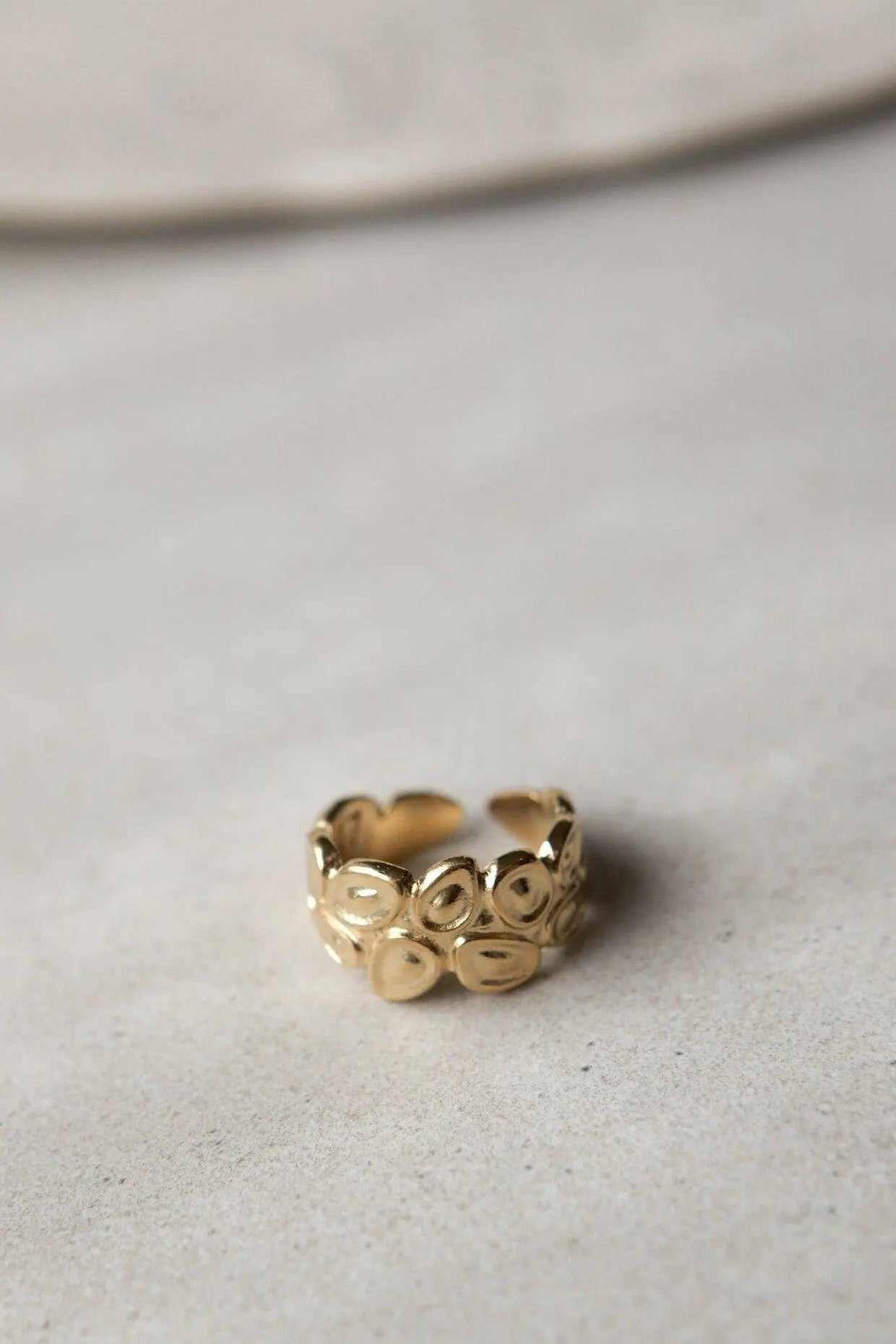 Pebbles WIDE RING in shiny gold-tone metal, a wide adjustable band with raised pebble-like oval details