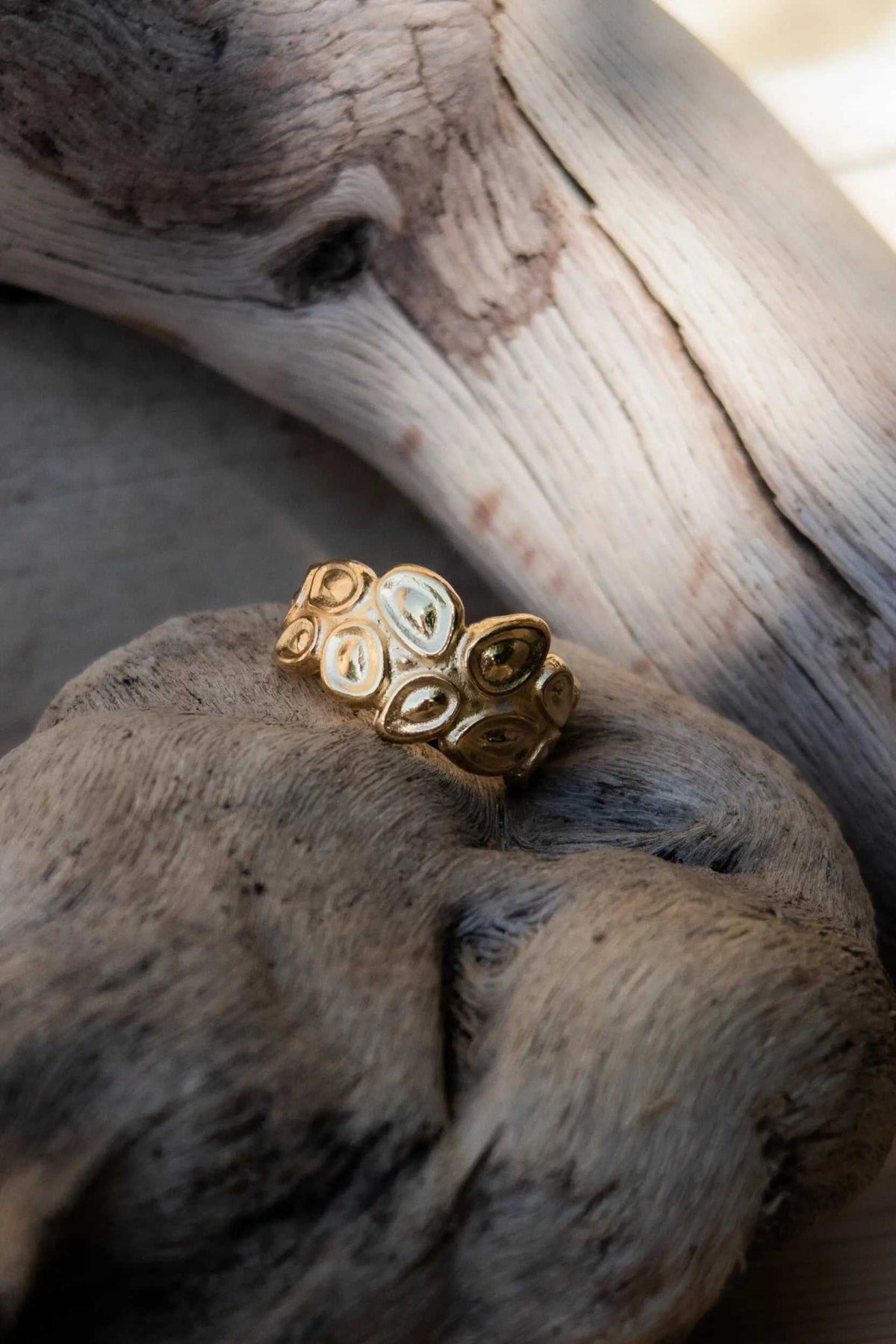 Pebbles WIDE RING in gold-tone metal, featuring a wide band of raised oval pebble shapes with pale inlays