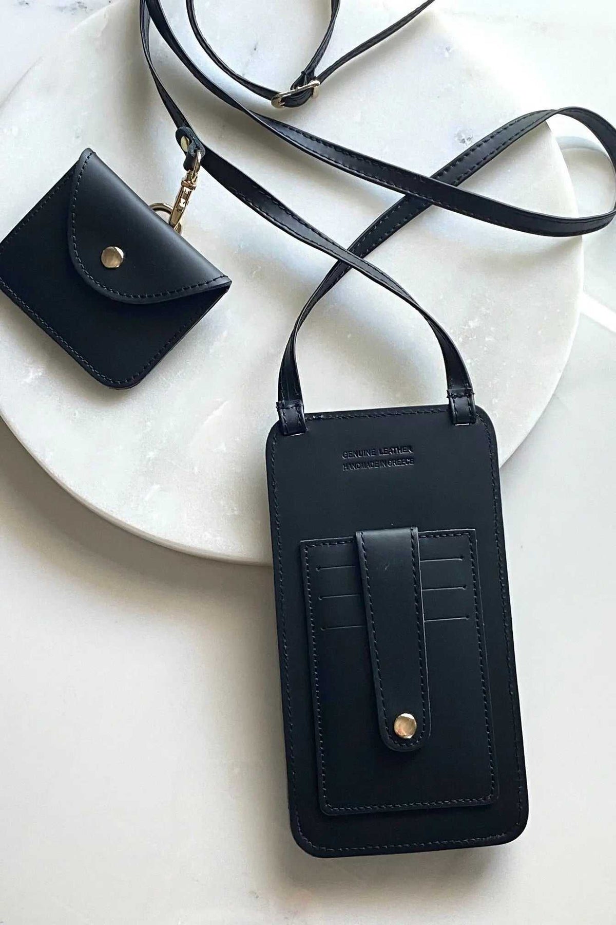 Phone Pouch in black full-grain leather with adjustable strap, snap closure, and matching coin purse