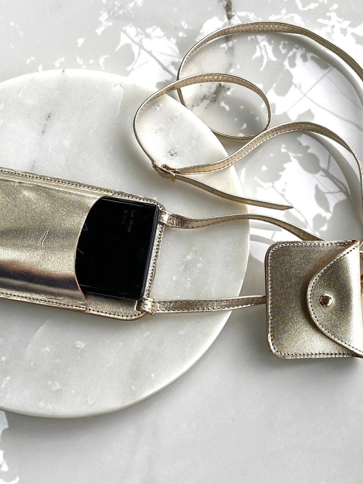 Phone Pouch in metallic gold leather with a long adjustable strap, snap-flap pocket and phone compartment