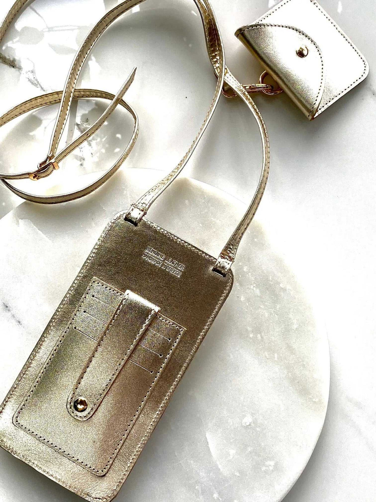 Phone Pouch in metallic gold leather with an adjustable shoulder strap, stitched front pocket and matching snap pouch
