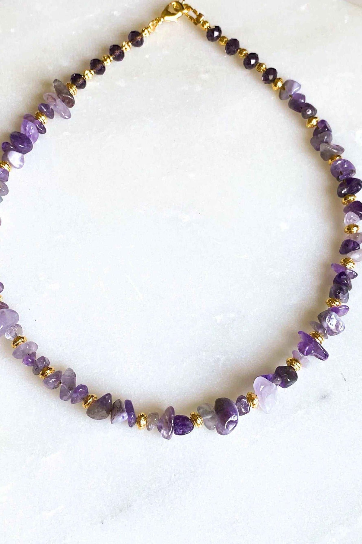 POLYMNIA Amethyst necklace with purple faceted stones, gold accents, and an adjustable chain closure