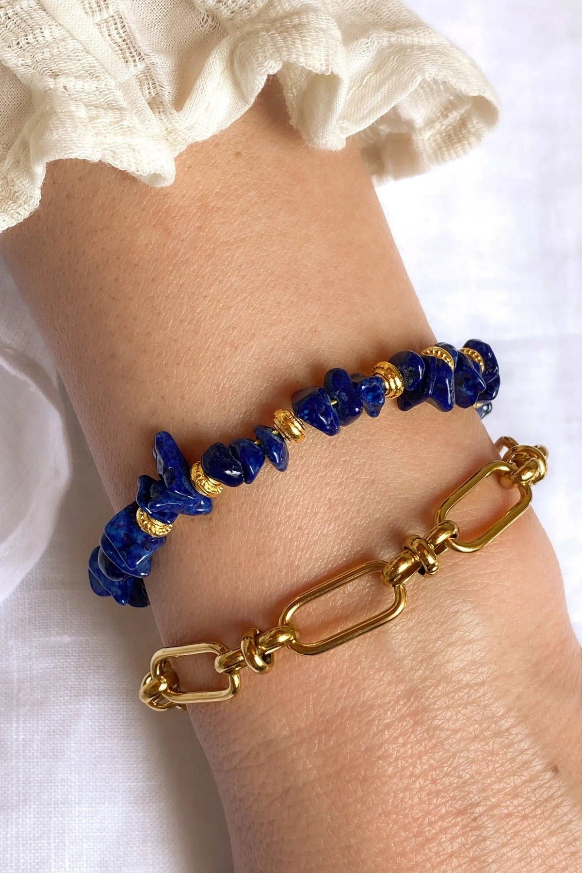 POLYMNIA BRACELET with deep blue irregular stone beads and gold-tone accents, paired with a chunky gold link bracelet