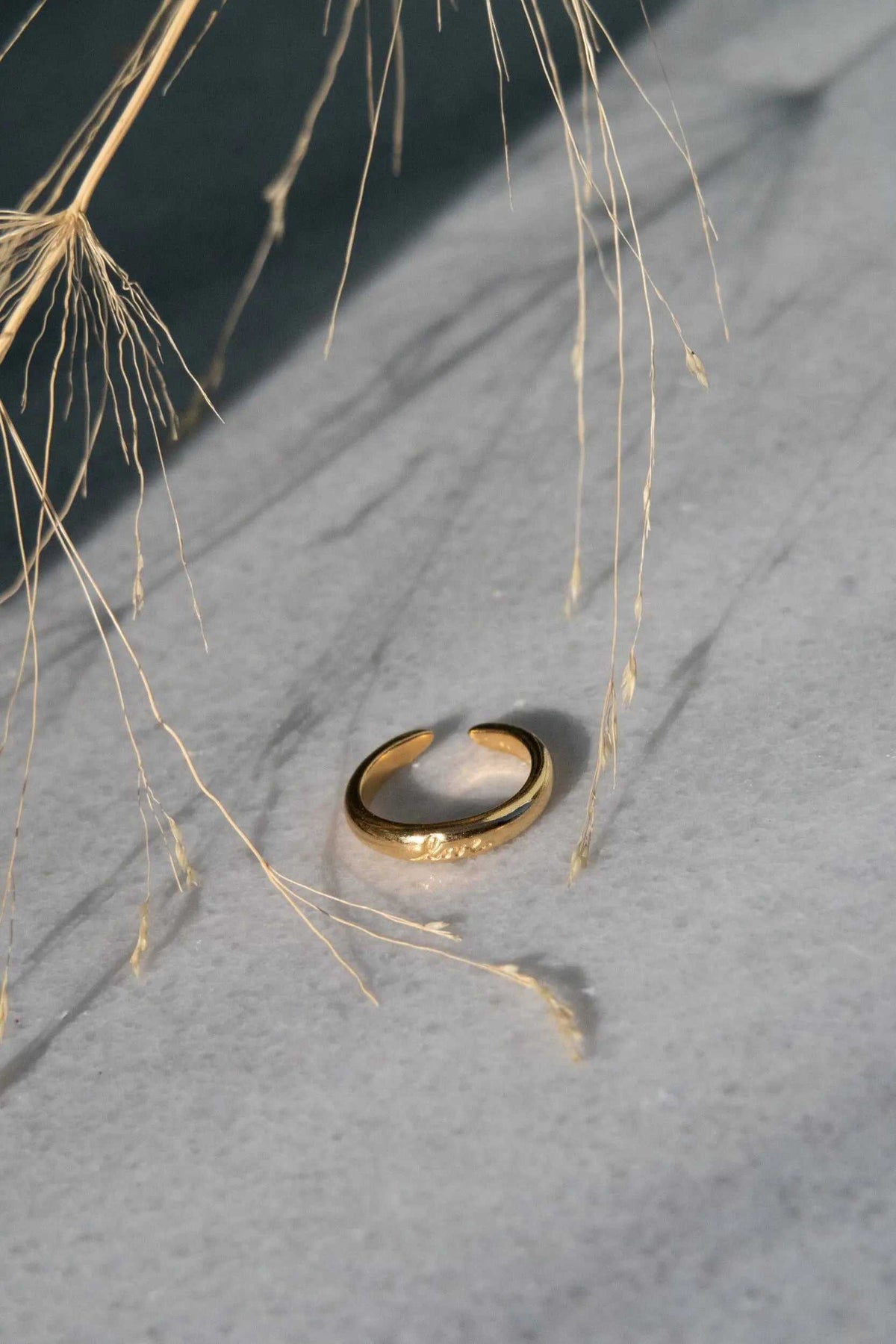 Promise LOVE ring, a gold-tone open band with a smooth domed profile and small engraved lettering
