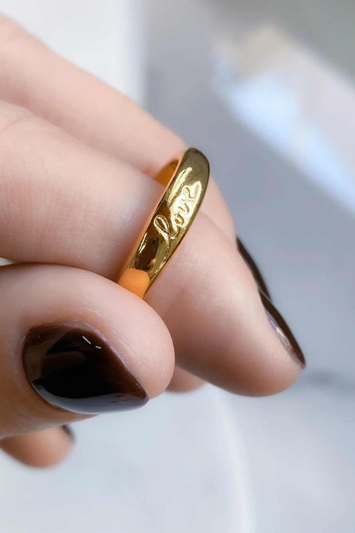 Promise LOVE ring, slim polished gold-tone band engraved with cursive love lettering and a smooth rounded profile