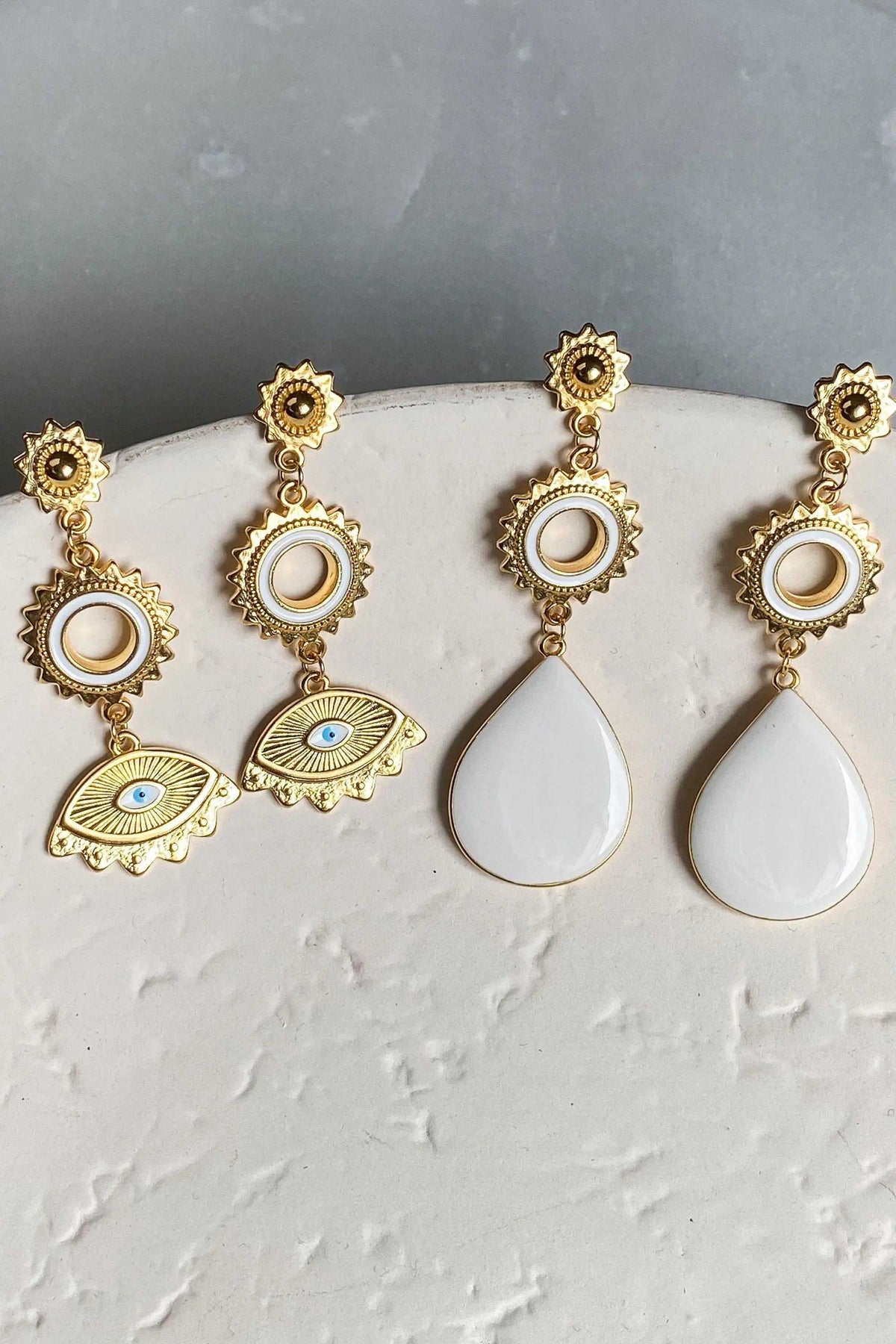 PYTHIA Statement Evil eye earrings in gold-tone metal, with white drops and round charms; two feature blue enamel eyes.