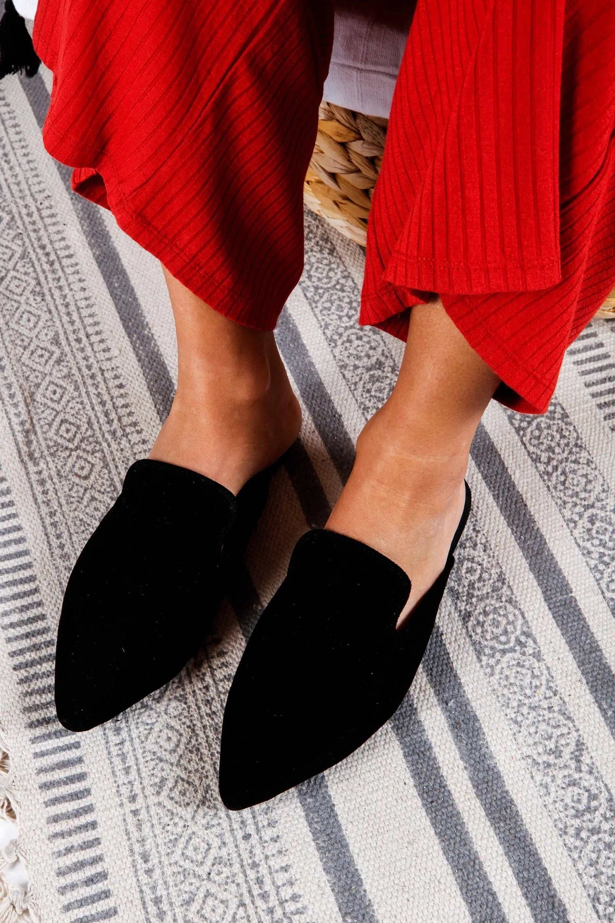 RAFAELA Handmade Greek Sandals, black suede mules with pointed toes and open backs, paired with red trousers
