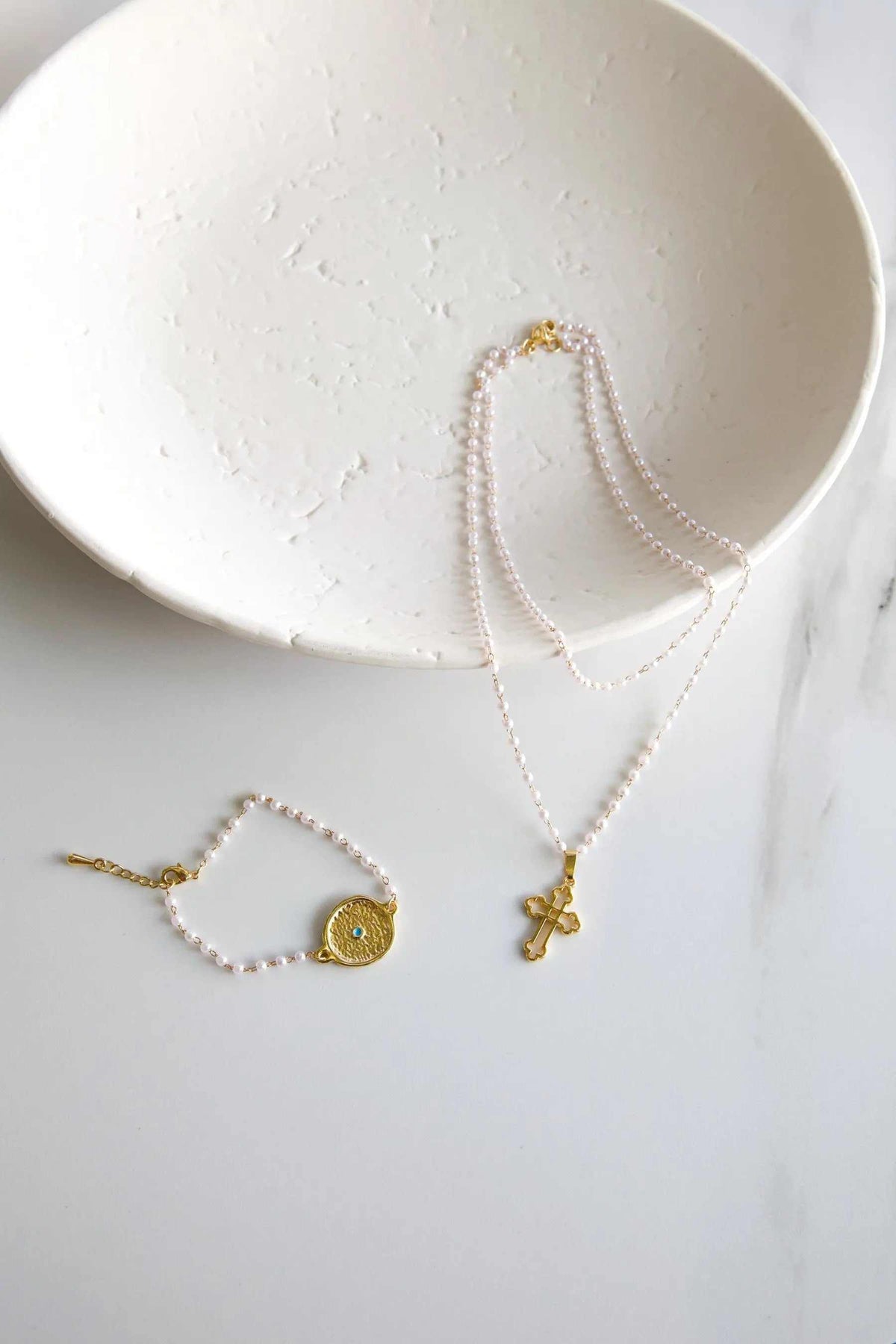 Rosario Pearls Bracelet with tiny white pearls and gold-tone circular eye charm, paired with matching cross necklace