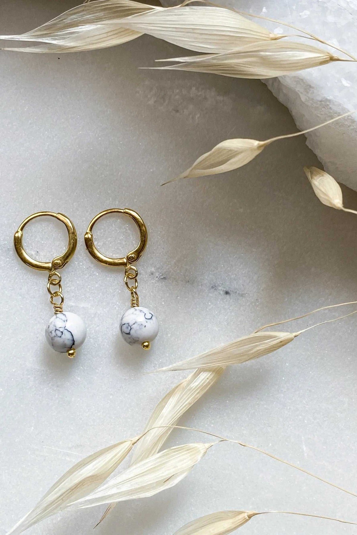 SABINA Gold Huggie Hoop Earrings with polished gold-tone hoops, delicate chain drops and white marbled bead charms