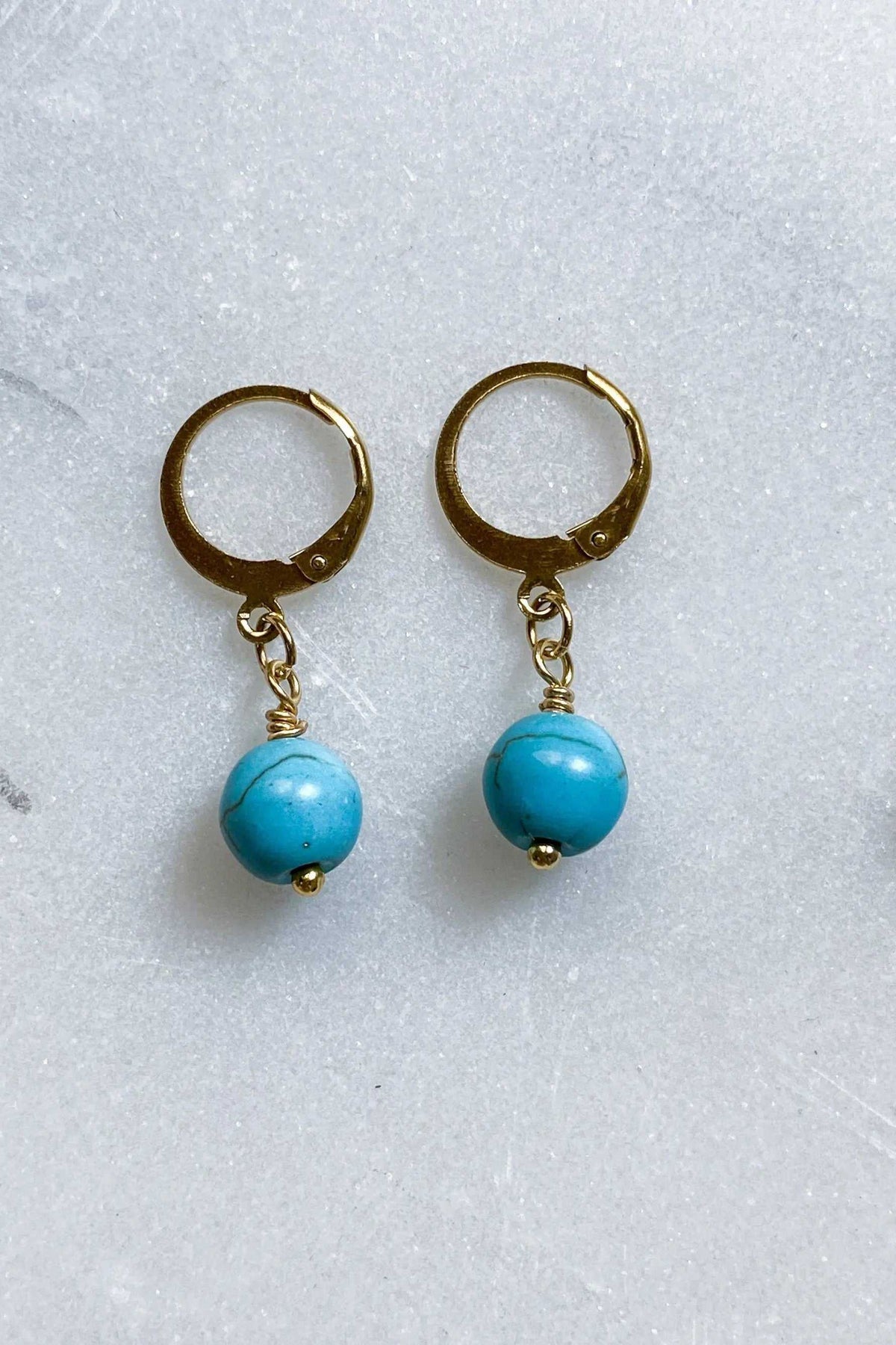 SABINA Gold Huggie Hoop Earrings with turquoise blue round bead charms and gold-plated hoops