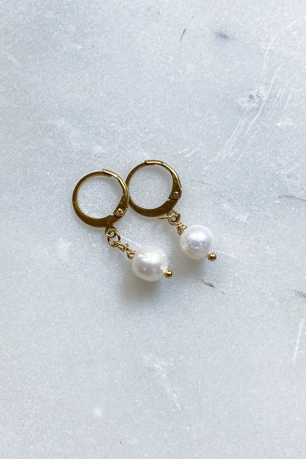 SABINA Gold Huggie Hoop Earrings with gold hoops and dangling white pearl charms